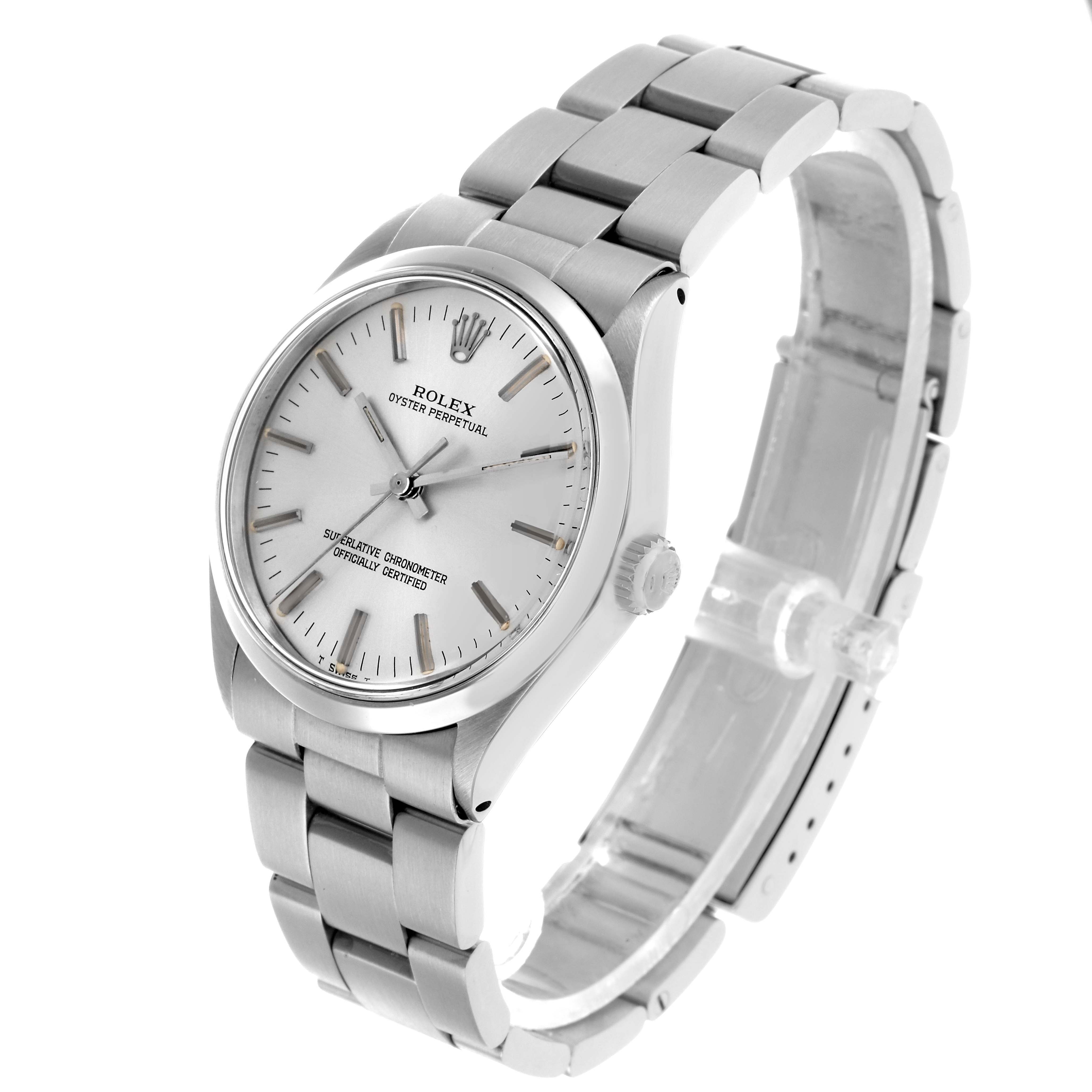 The Rolex Oyster Perpetual 1002 Men's Stainless Steel Silver Dial watch is shown at a three-quarter angle, highlighting the face, crown, and bracelet.
