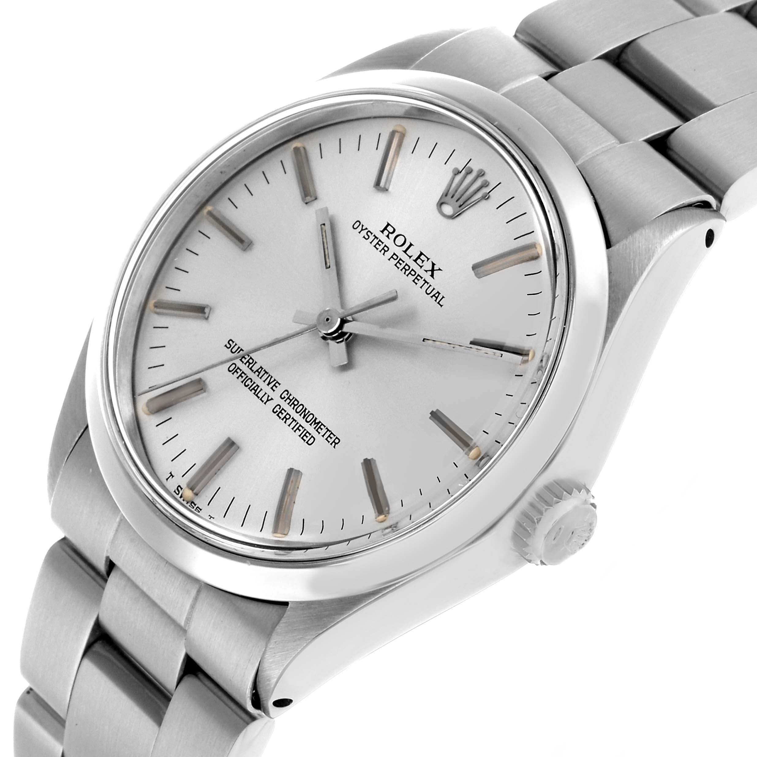 The Rolex Oyster Perpetual 1002 Men's Stainless Steel Silver Dial watch is shown at an angled view highlighting the dial, bezel, crown, and bracelet.