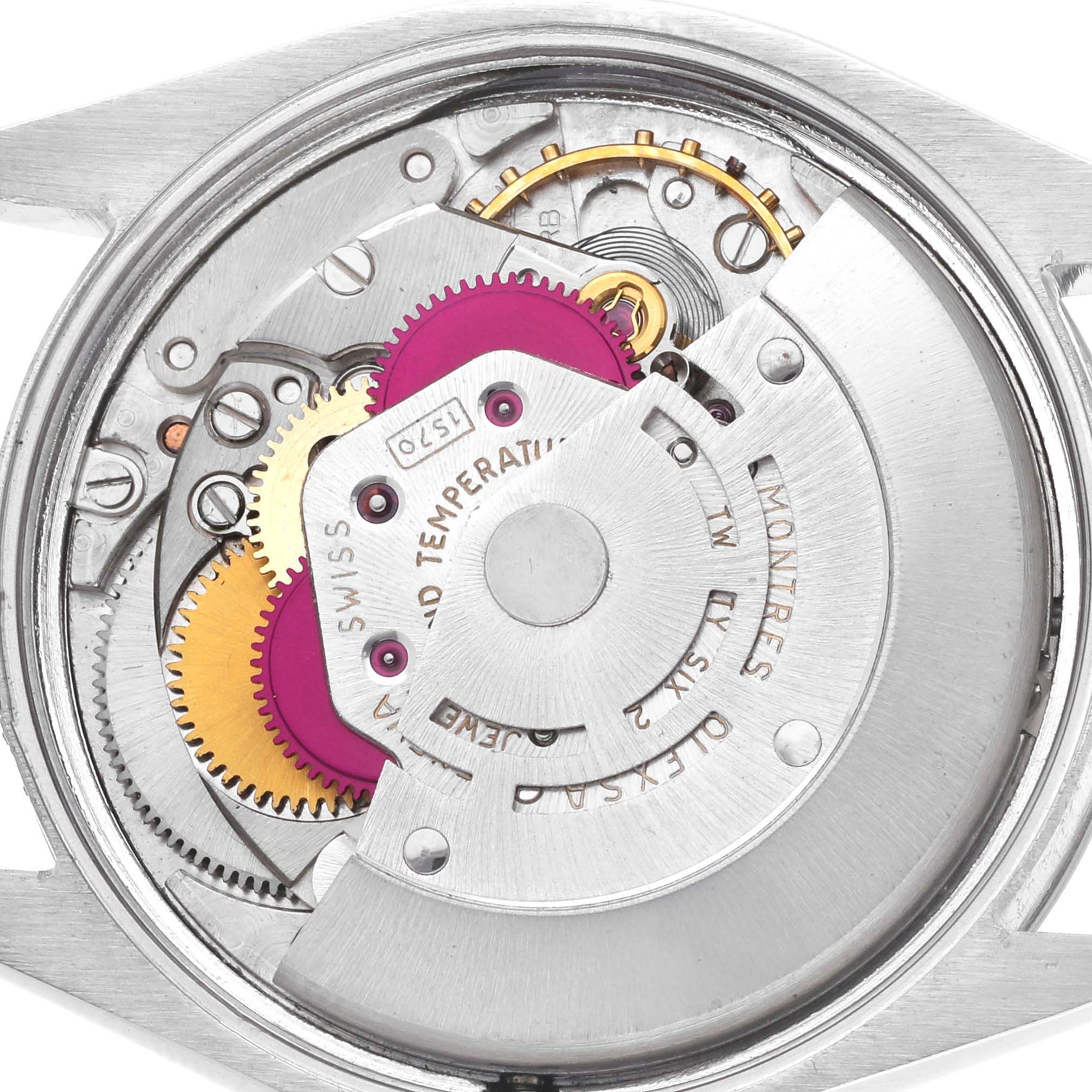 The image shows the movement of a Rolex Oyster Perpetual 1002 Men's Stainless Steel Silver Dial watch from a top-down angle, highlighting gears and mechanical components.