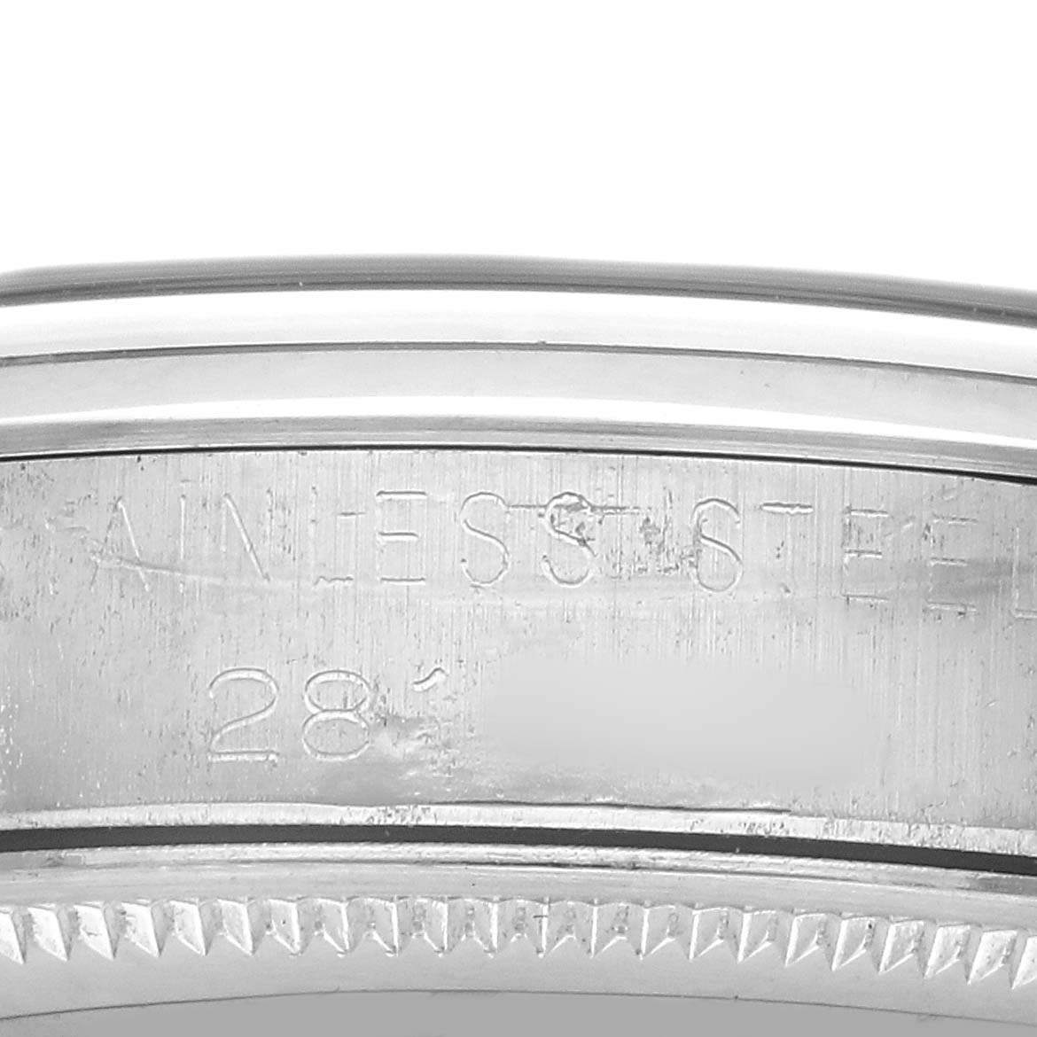 The image shows a close-up of the edge and case back of a Rolex Oyster Perpetual 1002 Men's Stainless Steel Silver Dial, highlighting the "Stainless Steel" engraving.