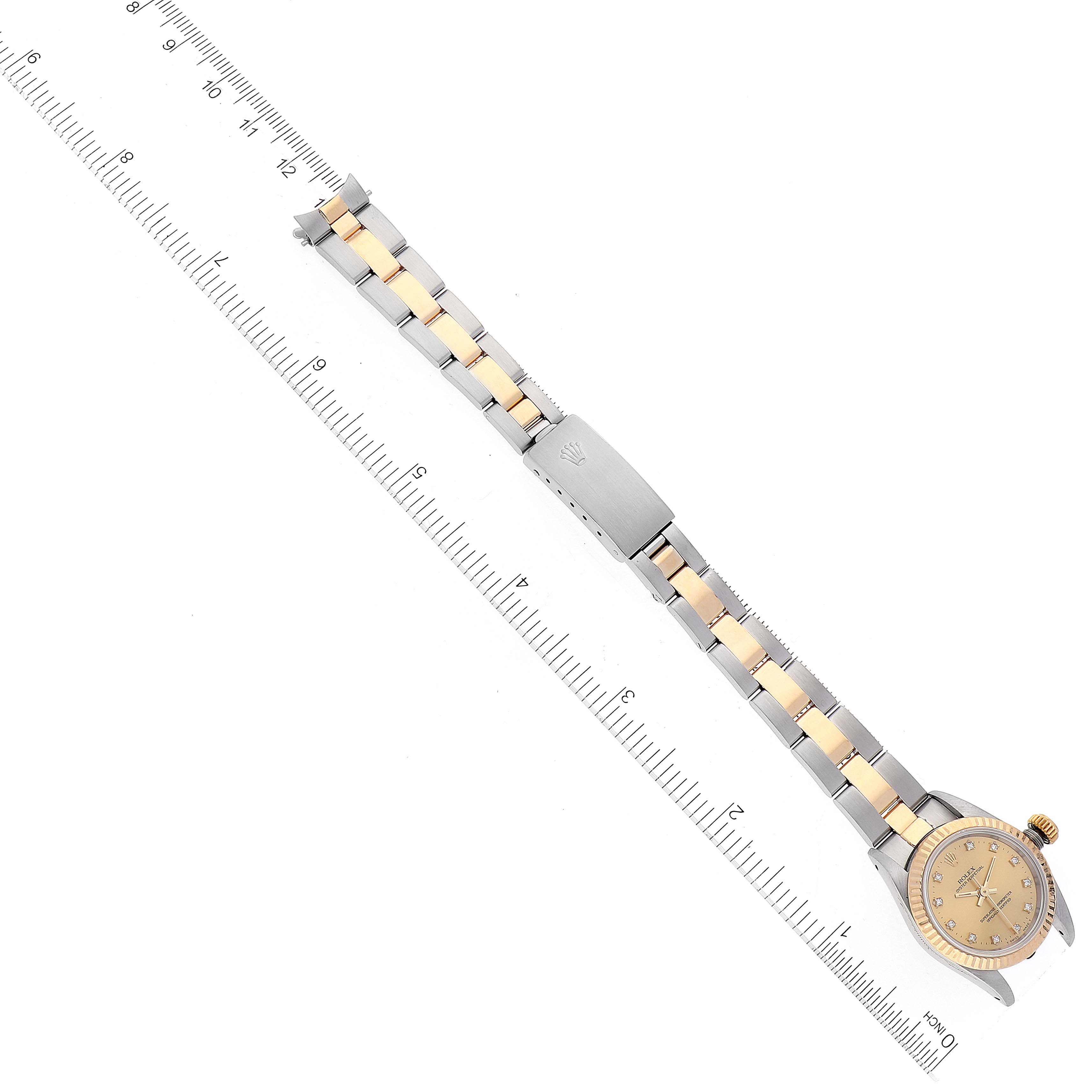 The image shows a Rolex Oyster Perpetual 67193 Women's Steel and Gold (two tone) Champagne Dial 67193 Women's Steel and Gold (two tone) Champagne Dial watch laid flat, displaying the watch face, bezel, and metal bracelet band alongside a ruler.