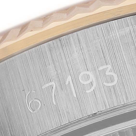 This close-up image shows the engraved case side of the Rolex Oyster Perpetual 67193 Women
s Steel and Gold (two tone) White Dial 67193 Women
s Steel and Gold (two tone) White Dial model.