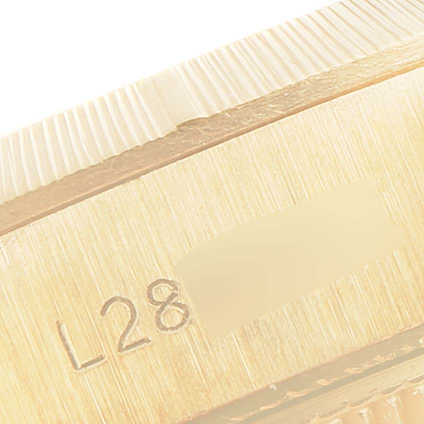 The image shows a close-up angle of the case and the bezel rim of a Rolex President 69278 Women
s Yellow Gold Champagne Dial 69278 Women
s Yellow Gold Champagne Dial model watch, highlighting the serial number engraving.