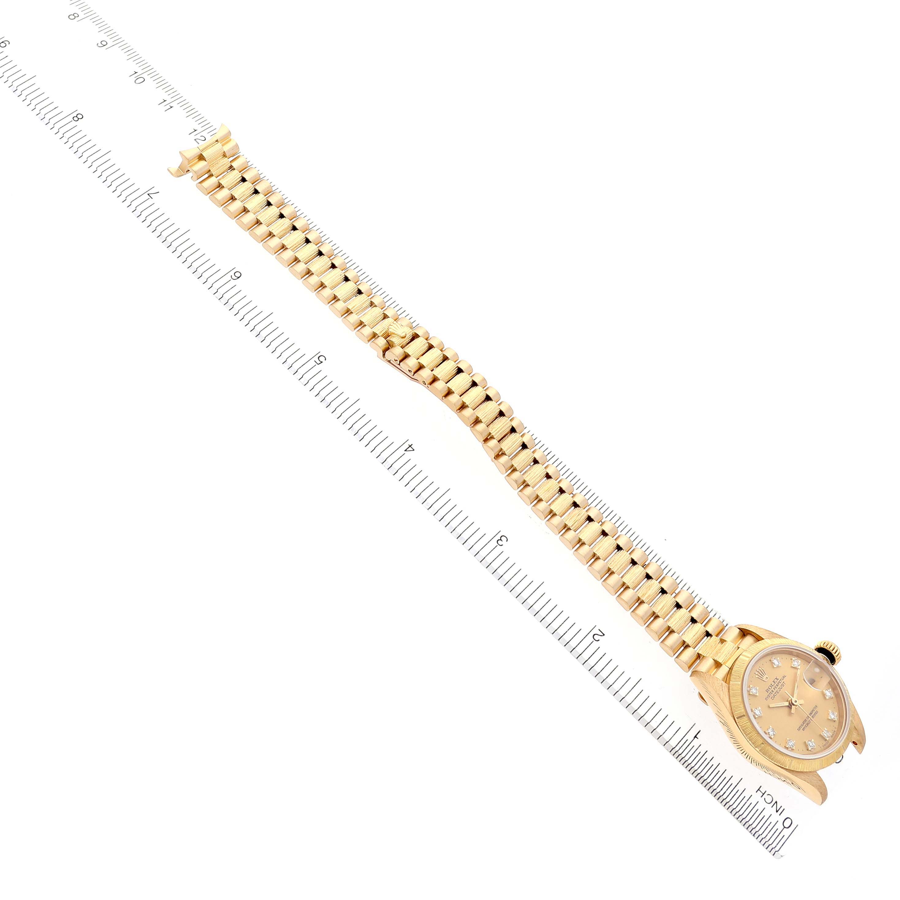 The Rolex President 69278 Women's Yellow Gold Champagne Dial 69278 Women's Yellow Gold Champagne Dial model watch is shown at a slight angle, highlighting the face and bracelet on a measuring ruler.