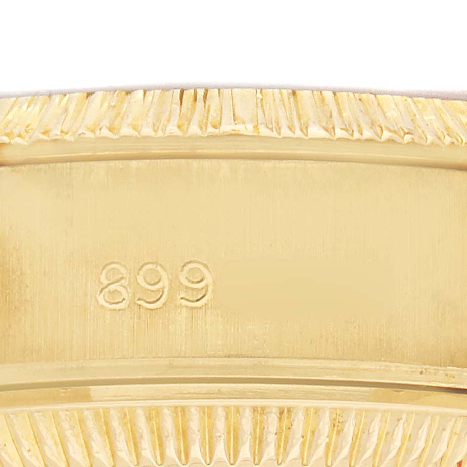 The image shows a close-up of the rehaut and part of the bezel of a Rolex President 69278 Women's Yellow Gold Champagne Dial watch, featuring engraved details.