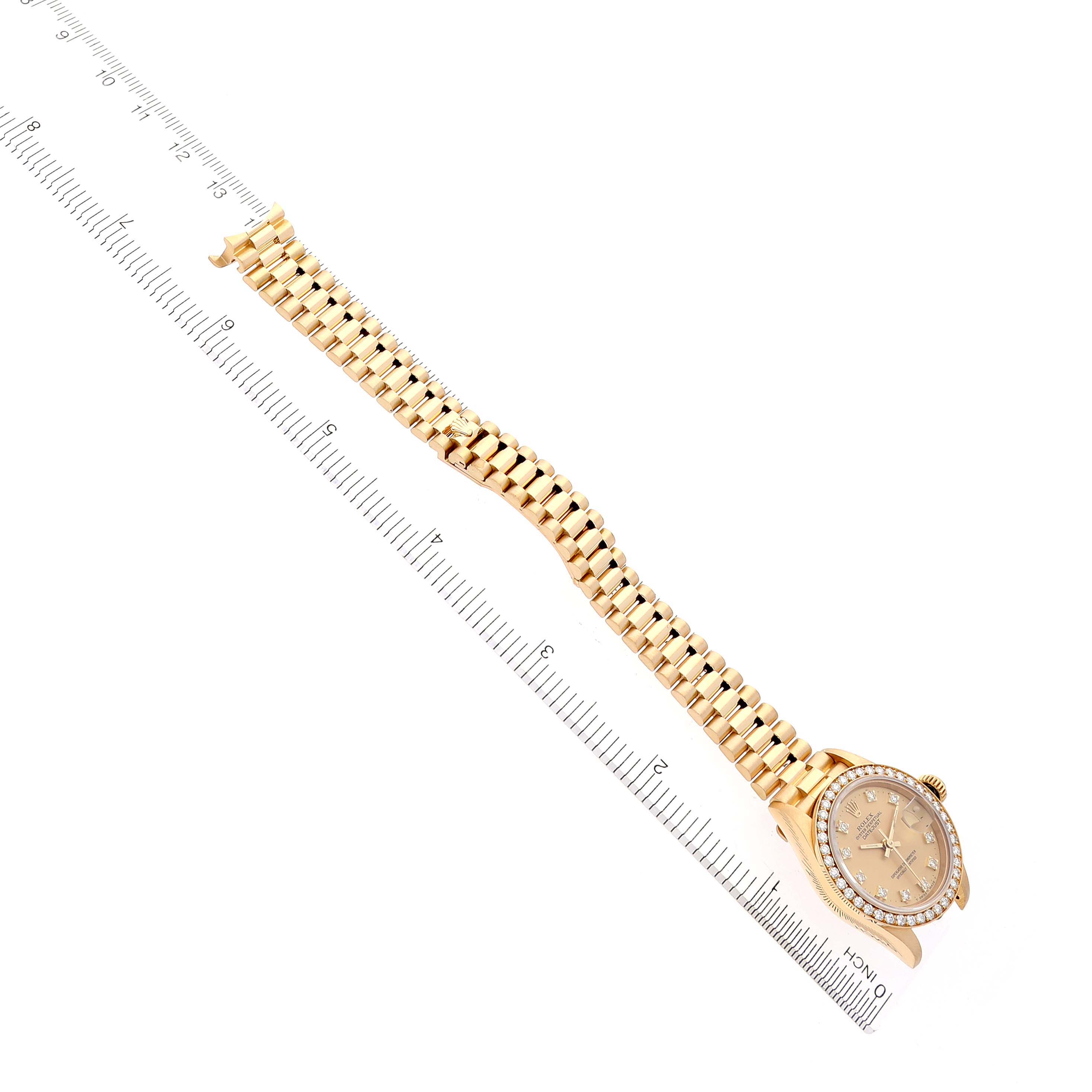 The image shows a Rolex President 69138 Women's Yellow Gold Champagne Dial 69138 Women's Yellow Gold Champagne Dial watch from a top-down angle, displaying the bracelet and dial next to a ruler.