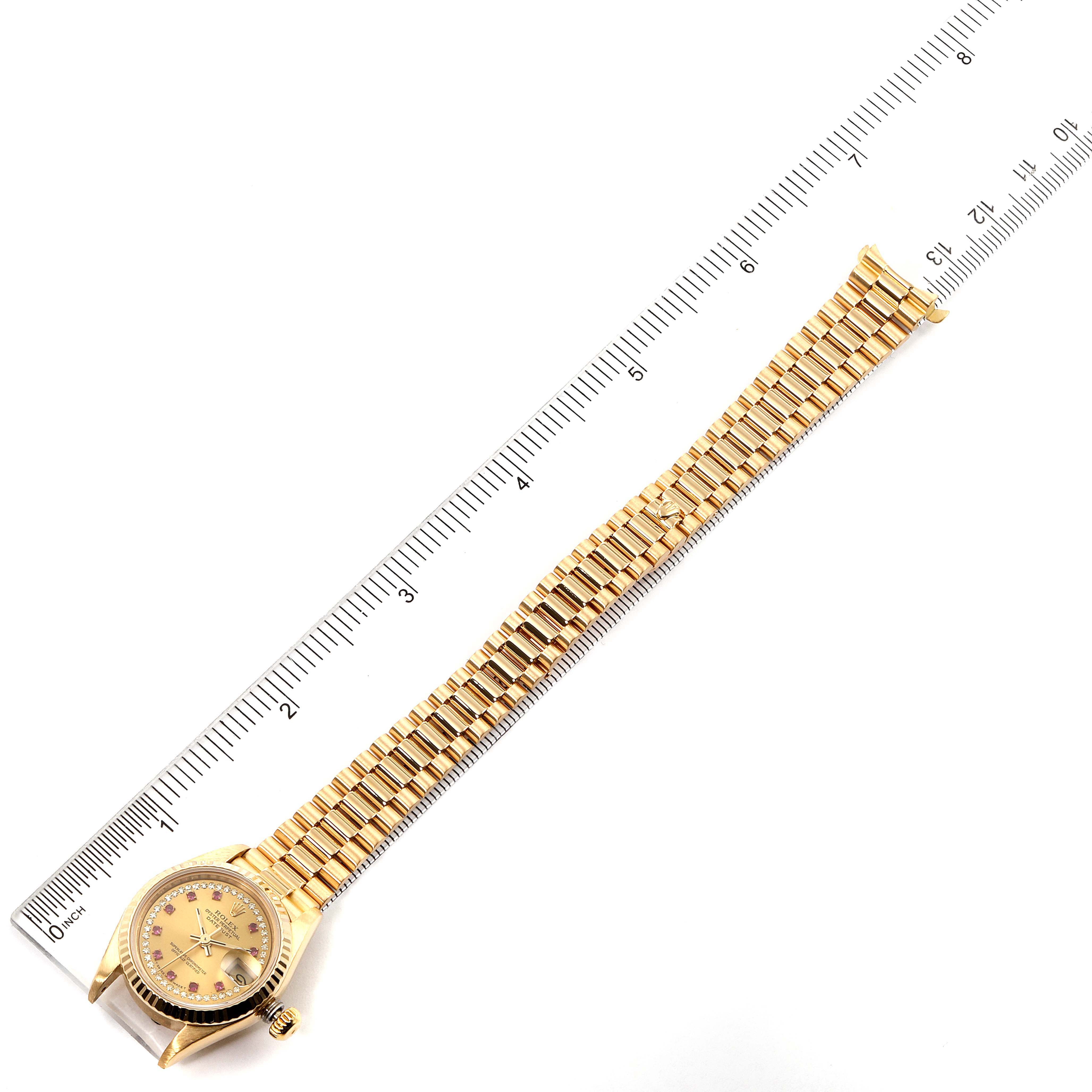 The Rolex President 69178 Women
s Yellow Gold Champagne Dial 69178 Women
s Yellow Gold Champagne Dial model watch is shown fully extended flat, with its face, gold band, and crown visible alongside a ruler for scale.