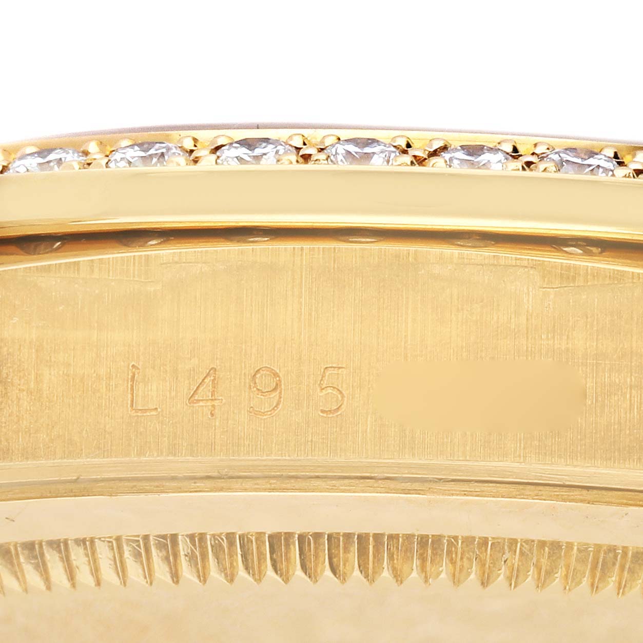 The image shows a close-up of the side of a Rolex President 18348 Men
s Yellow Gold Champagne Dial 18348 Men
s Yellow Gold Champagne Dial watch, focusing on the engraved serial number and diamond-set bezel.