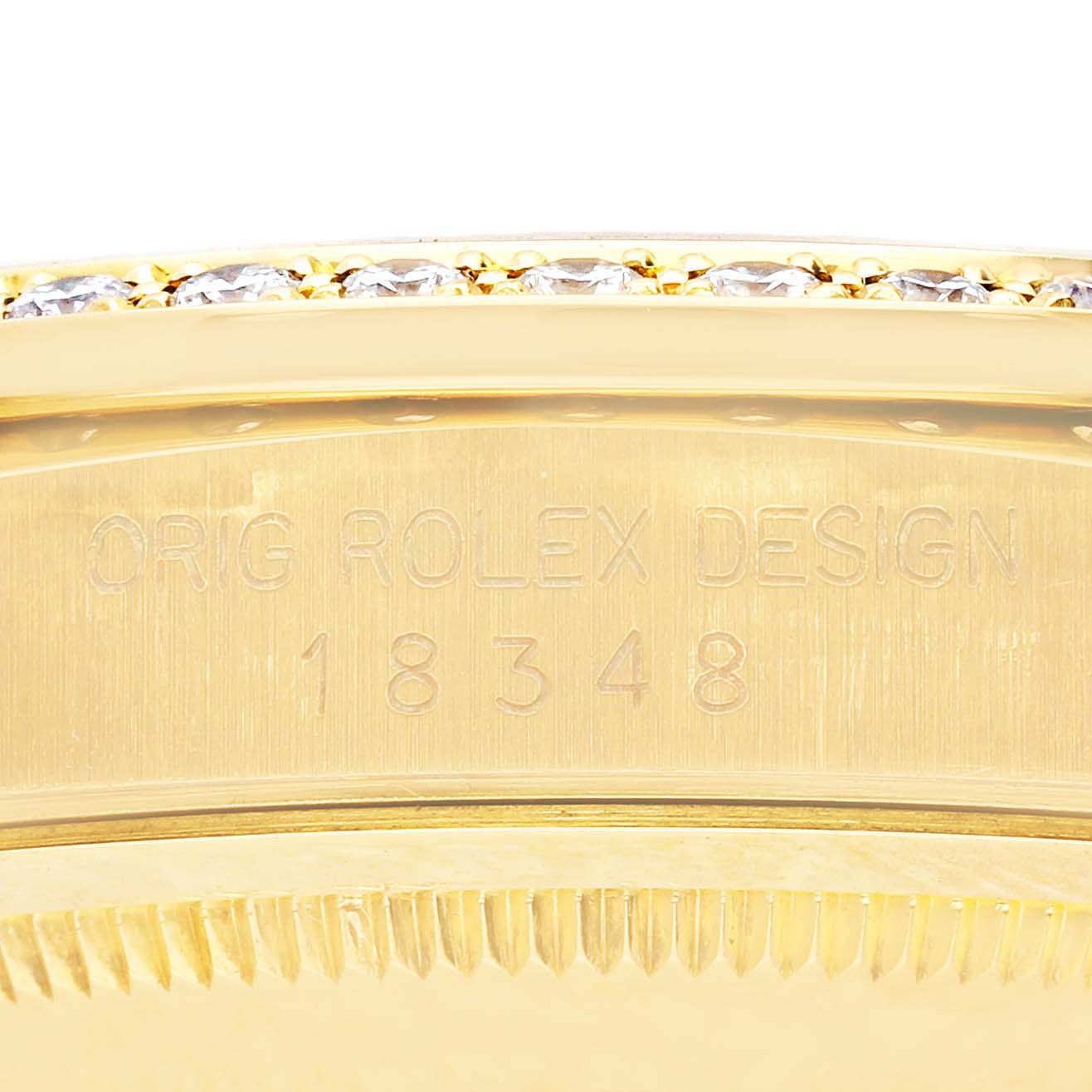 The image shows a close-up of the Rolex President 18348 Men
s Yellow Gold Champagne Dial 18348 Men
s Yellow Gold Champagne Dial model
s gold side case with a diamond bezel and engraved model number.