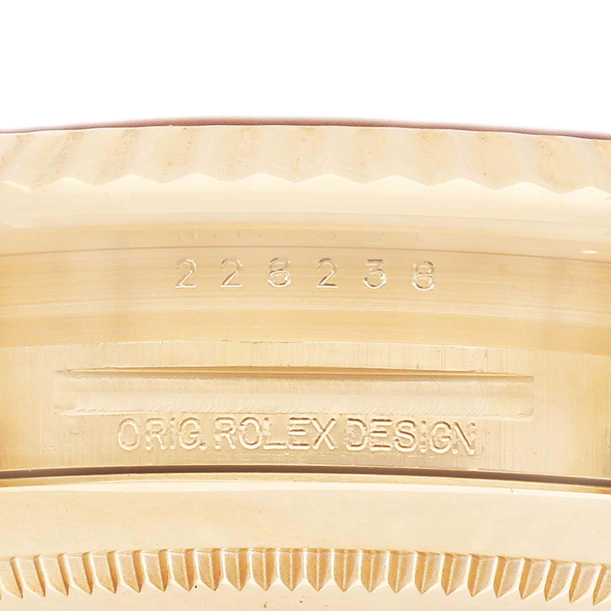 The image shows a close-up of the Rolex President 228238 Men's Yellow Gold Champagne Dial model's side, highlighting the engraved bezel and case details.