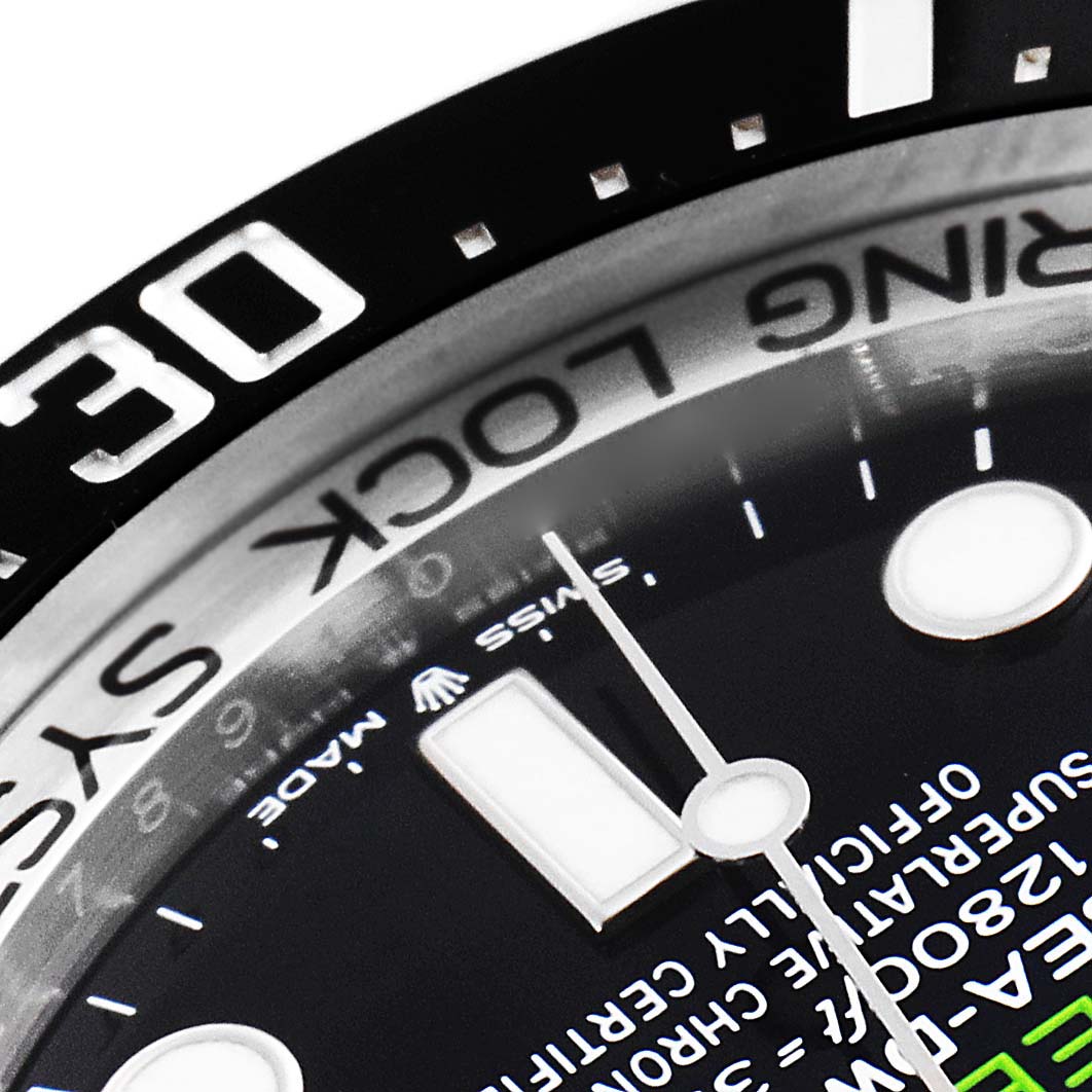 This close-up image of the Rolex Sea-Dweller 126660 Men
s Stainless Steel Blue Dial 126660 Men
s Stainless Steel Blue Dial watch shows part of the bezel, dial, and hour markers at an angle.