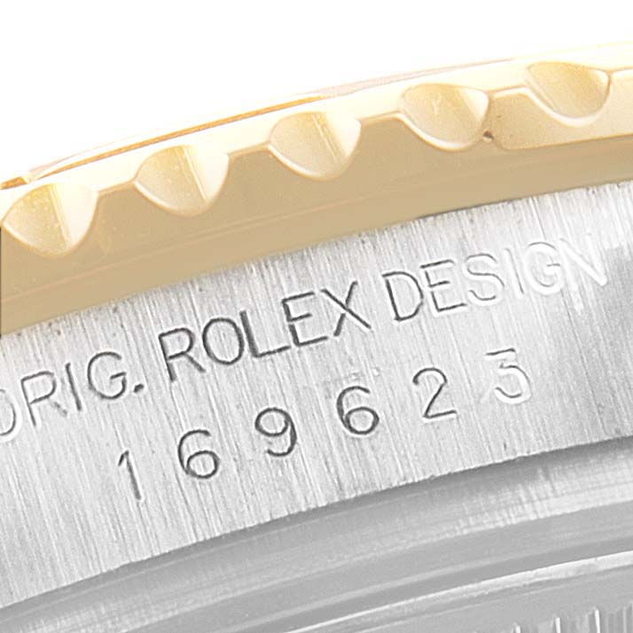 This close-up angle shows the engraving "ORIG. ROLEX DESIGN 169623" on the case of a Rolex Yacht-Master 169623 Women's Steel and Gold (two tone) Blue Dial 169623 Women's Steel and Gold (two tone) Blue Dial watch.