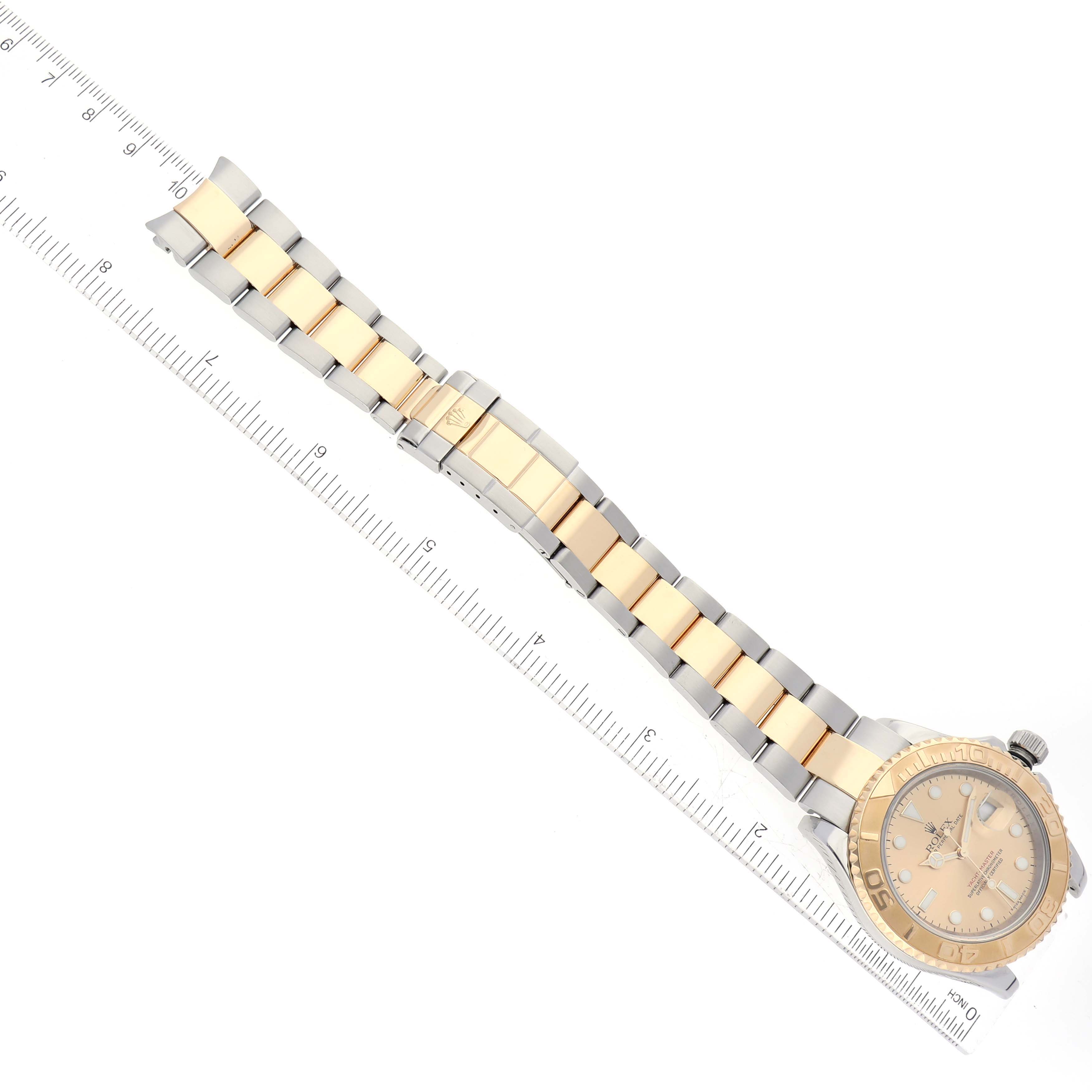 The Rolex Yacht-Master 16623 Men's Steel and Gold (two tone) Champagne Dial 16623 Men's Steel and Gold (two tone) Champagne Dial model watch is shown flat on its side, displaying the full bracelet and dial, with a ruler next to it for scale.