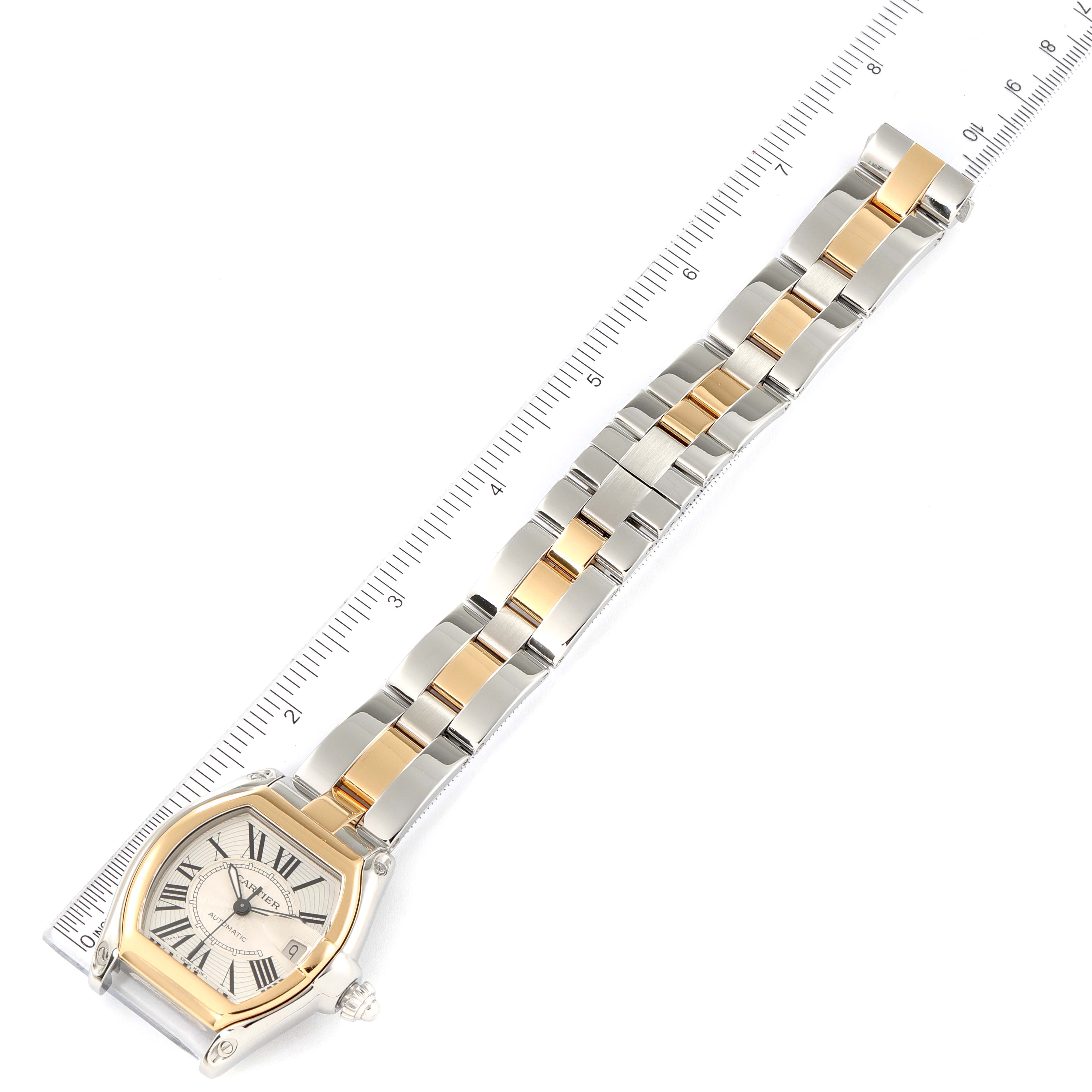The Cartier Roadster W62031Y4 Men
s Steel and Gold (two tone) Silver Dial W62031Y4 Men
s Steel and Gold (two tone) Silver Dial watch is shown from an overhead angle, displaying its face, band, and measurement against a ruler.