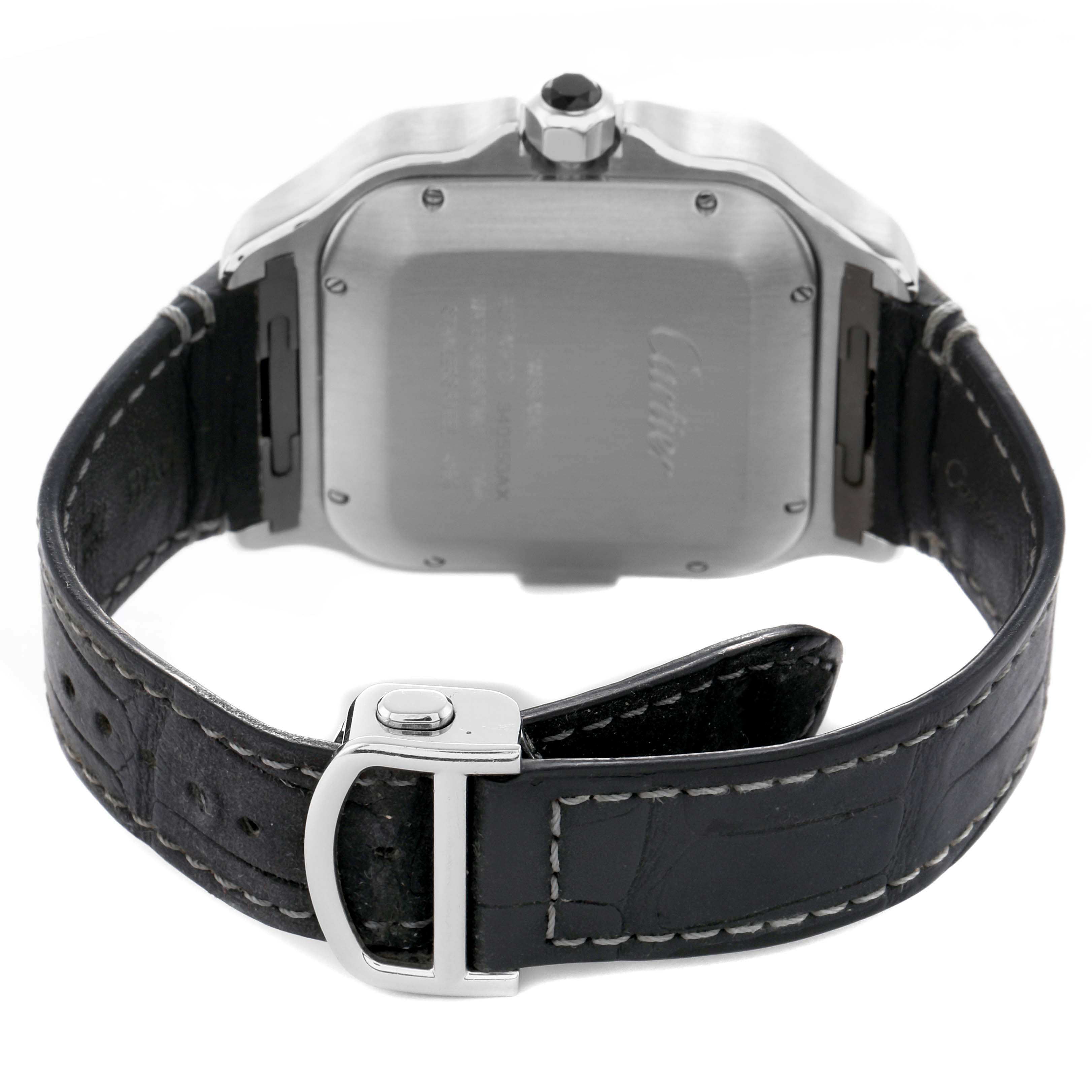 The Cartier Santos WSSA0017 Men's Stainless Steel Silver Dial watch is shown from the back, highlighting the case, crown, and black leather strap with a deployment clasp.