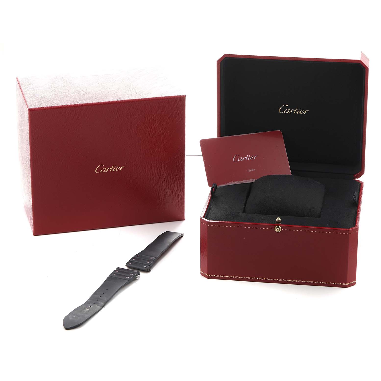 The image shows a Cartier Santos WSSA0017 Men's Stainless Steel Silver Dial watch box, an open case, a folded card, and a black watch strap laid out beside them.