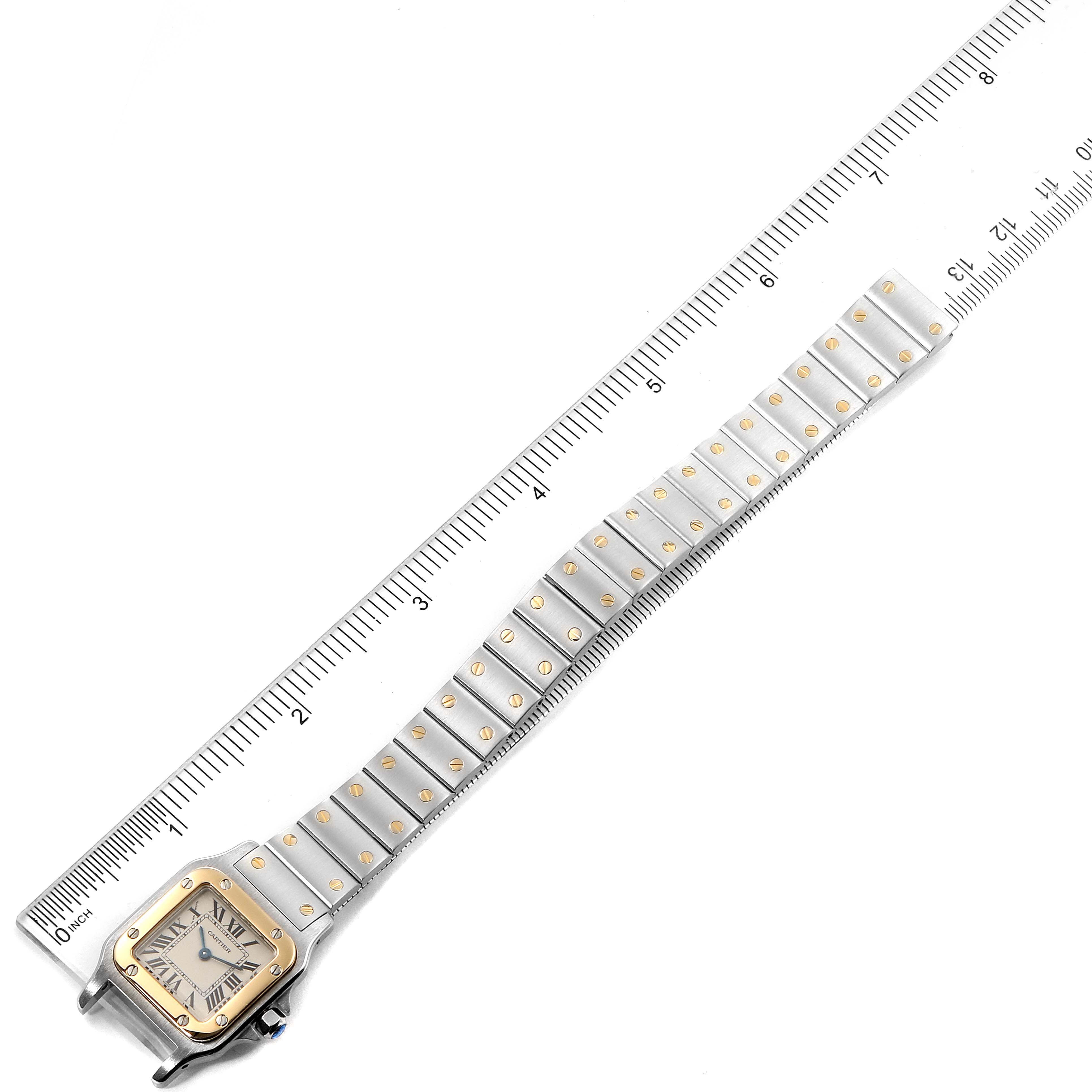 The Cartier Santos W20012C4 Women's Steel and Gold (two tone) Silver Dial W20012C4 Women's Steel and Gold (two tone) Silver Dial watch is shown from a top-down angle, displaying the full strap and face, with a ruler for scale.