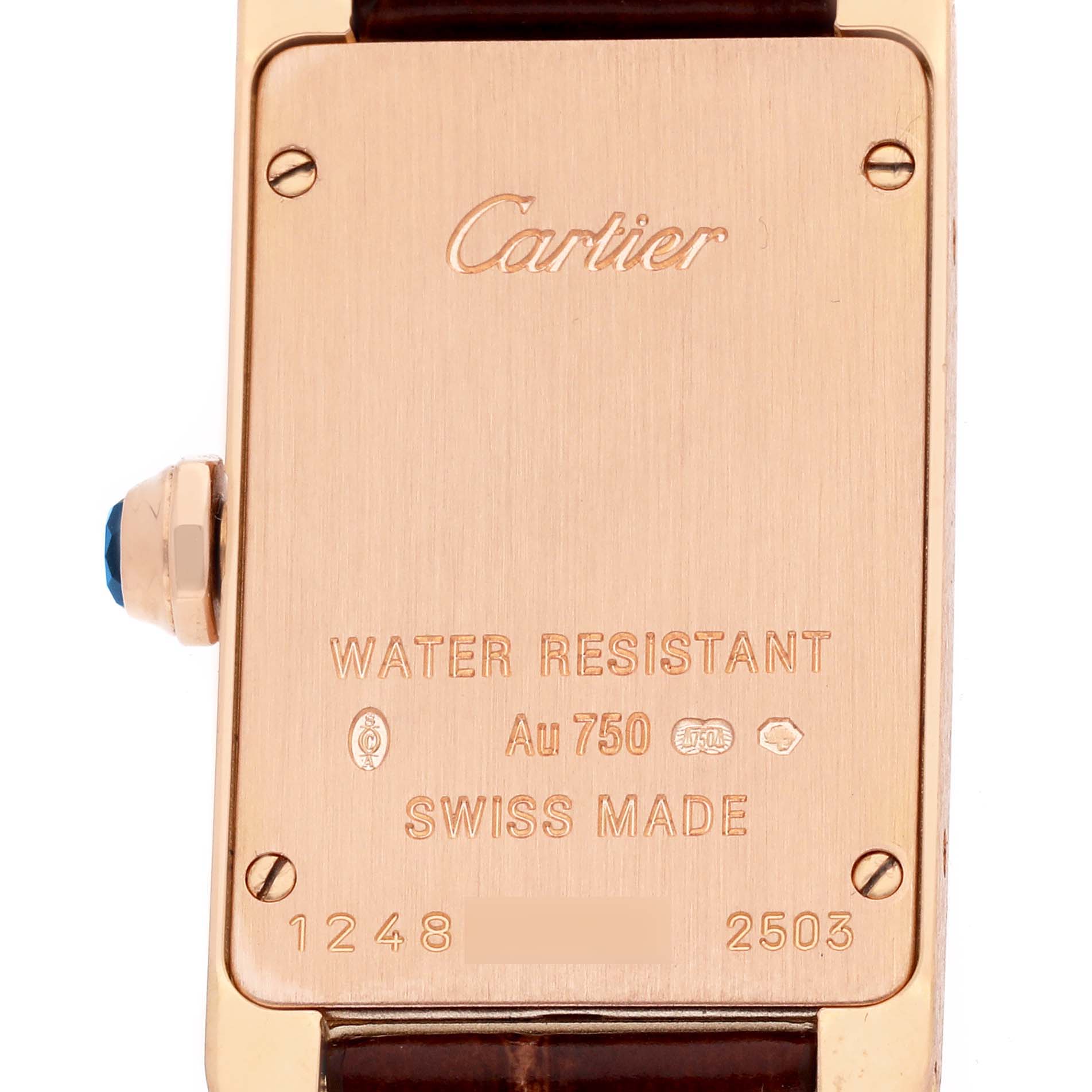 The image shows the back case of the Cartier Tank Américaine watch, displaying its engravings and a side view of the crown.