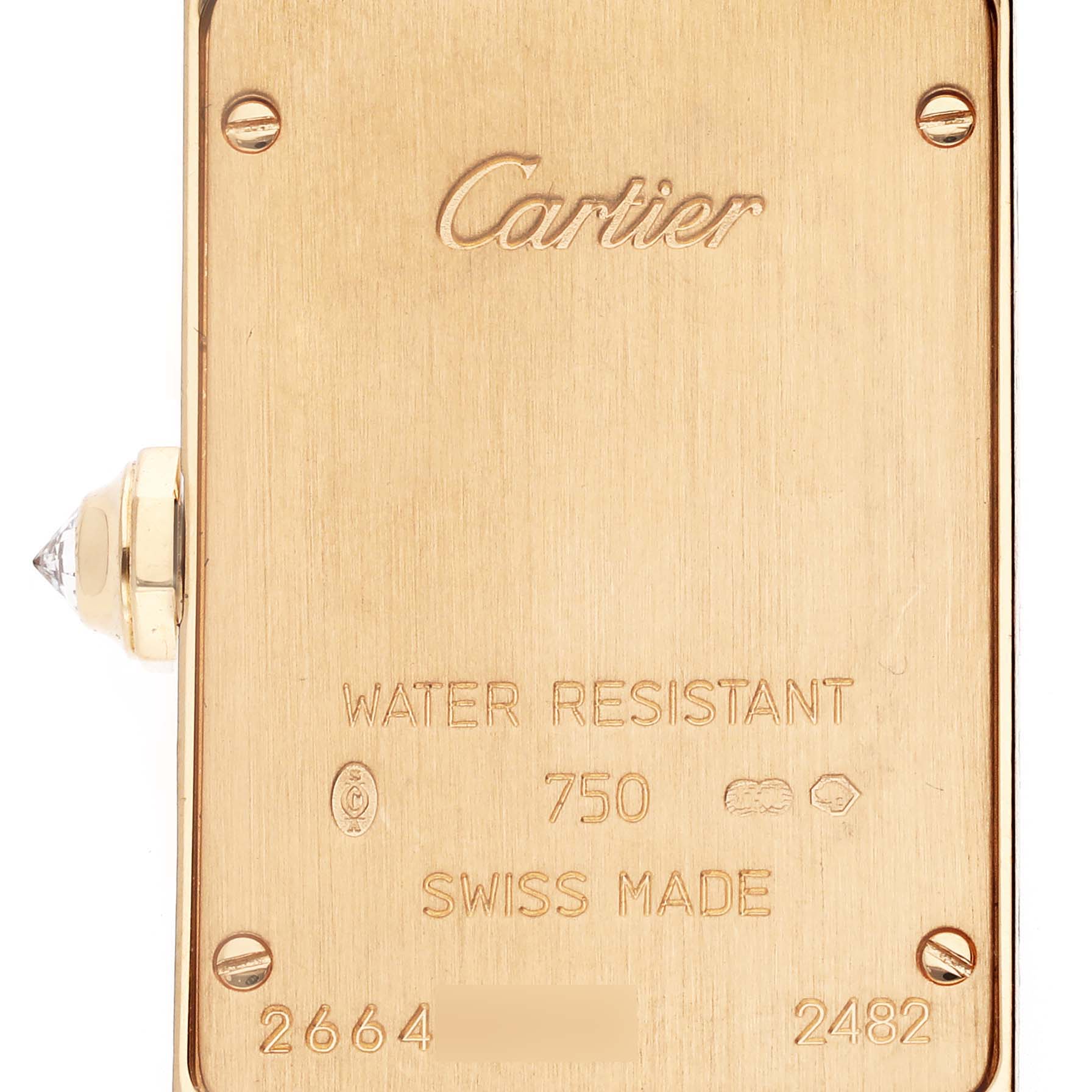 The image displays the back plate of a Cartier Tank Americaine WB7012K2 Women's Yellow Gold Silver Dial WB7012K2 Women's Yellow Gold Silver Dial watch, showing engravings and a side view of the crown.