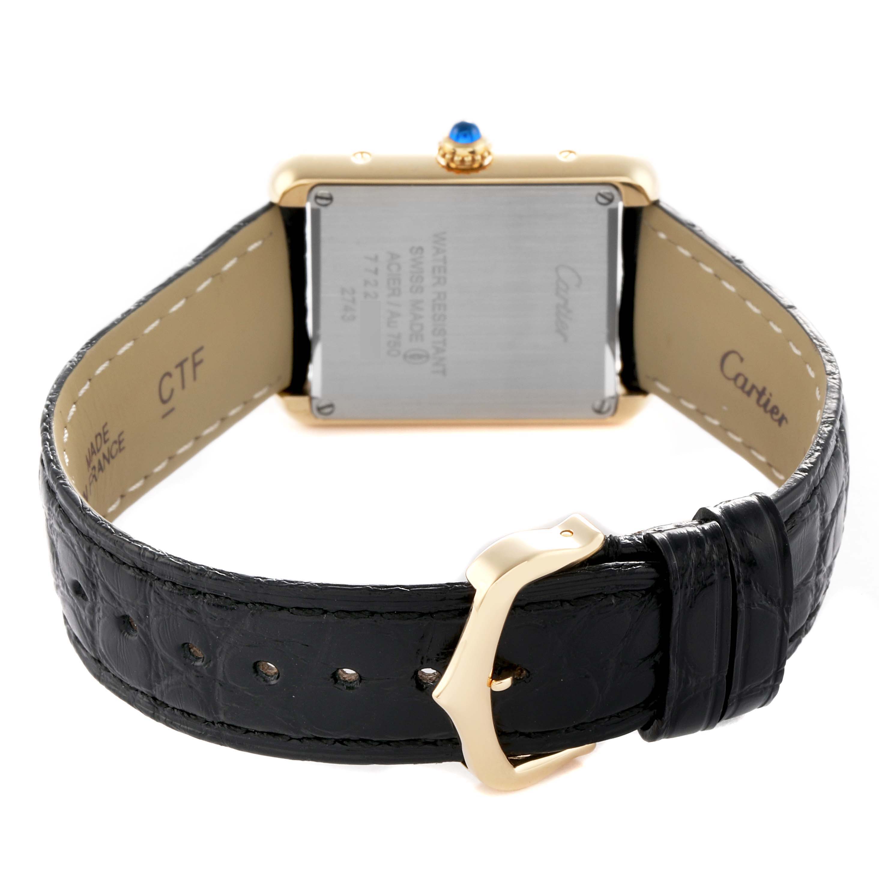 The image shows the back of a Cartier Tank Solo W1018755 Women's Yellow Gold Silver Dial watch, highlighting the case back, crown, and leather strap with buckle.