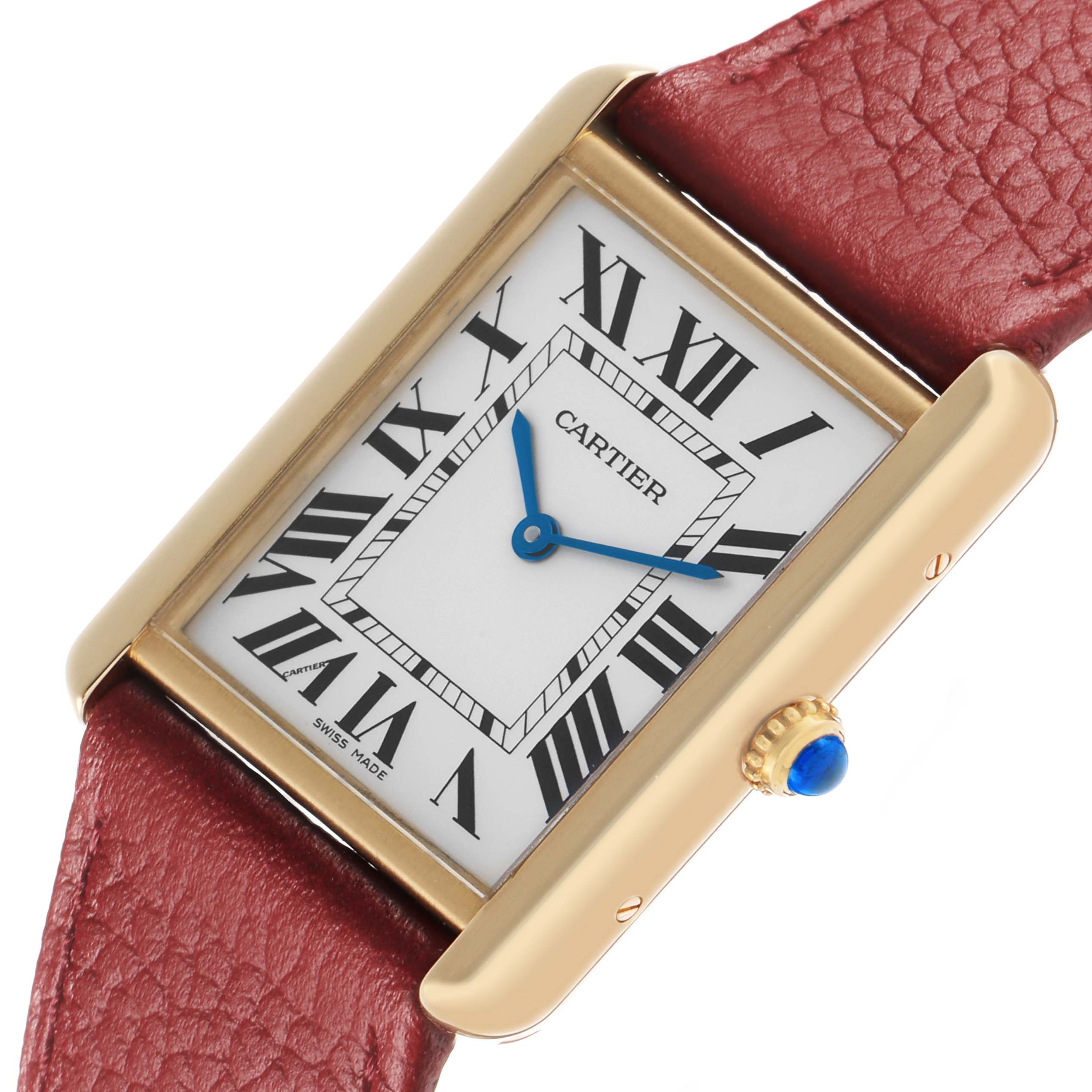 The Cartier Tank Solo W1018855 Men's Yellow Gold Silver Dial watch is shown at a slight angle, highlighting the gold case, white dial with Roman numerals, blue hands, and red leather strap.