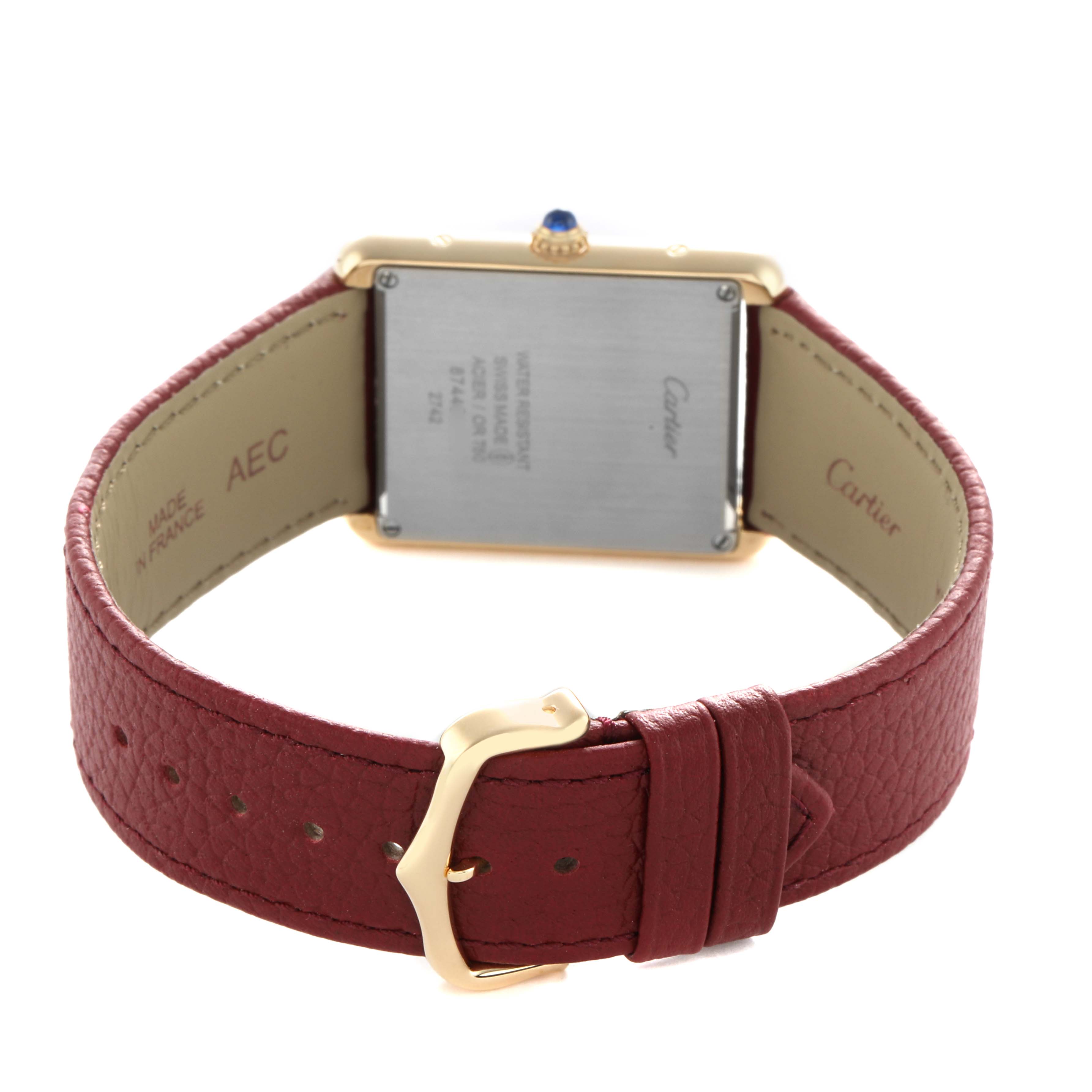 The Cartier Tank Solo W1018855 Men's Yellow Gold Silver Dial watch is shown from the back, displaying the case back, crown, and red leather strap with buckle.