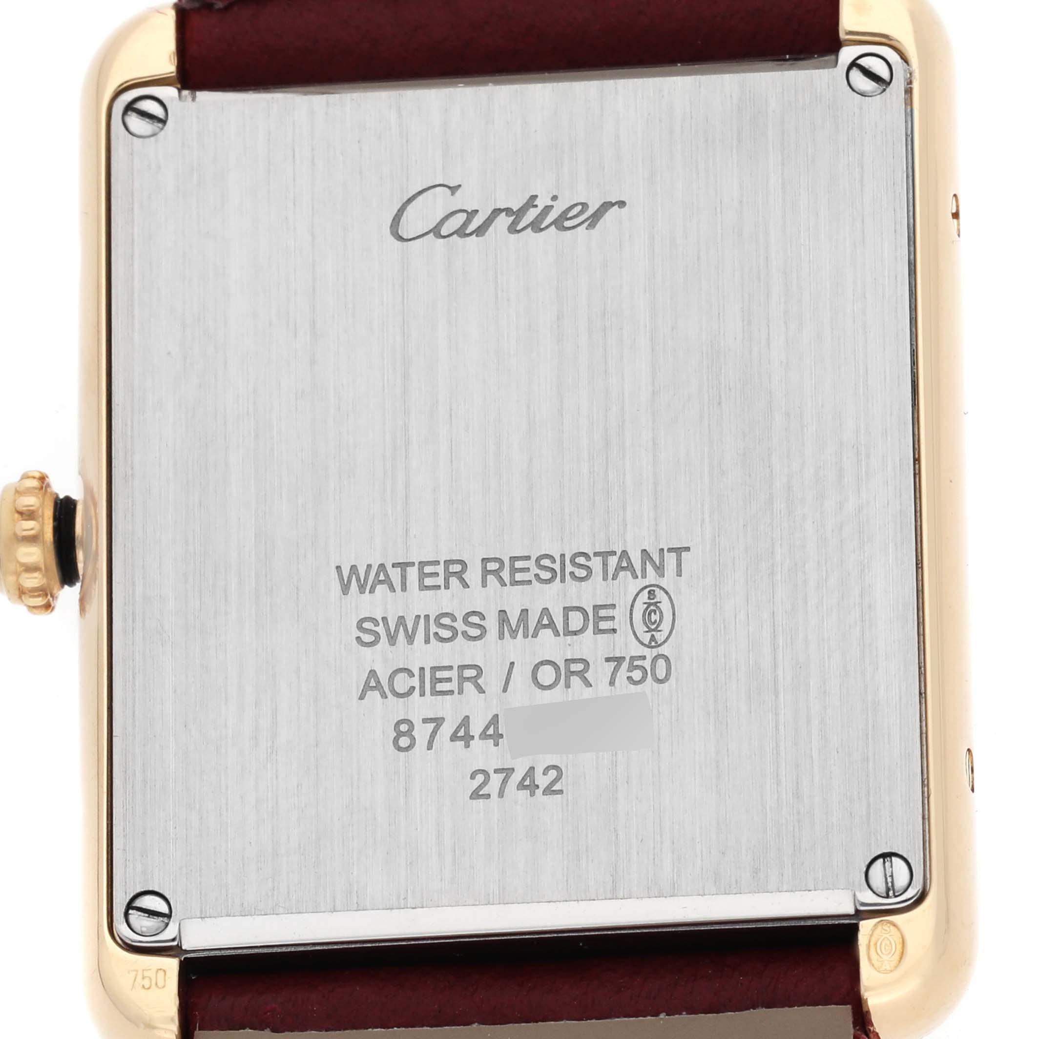 The image shows the back of a Cartier Tank Solo W1018855 Men's Yellow Gold Silver Dial watch, highlighting the brand engraving and specifications.