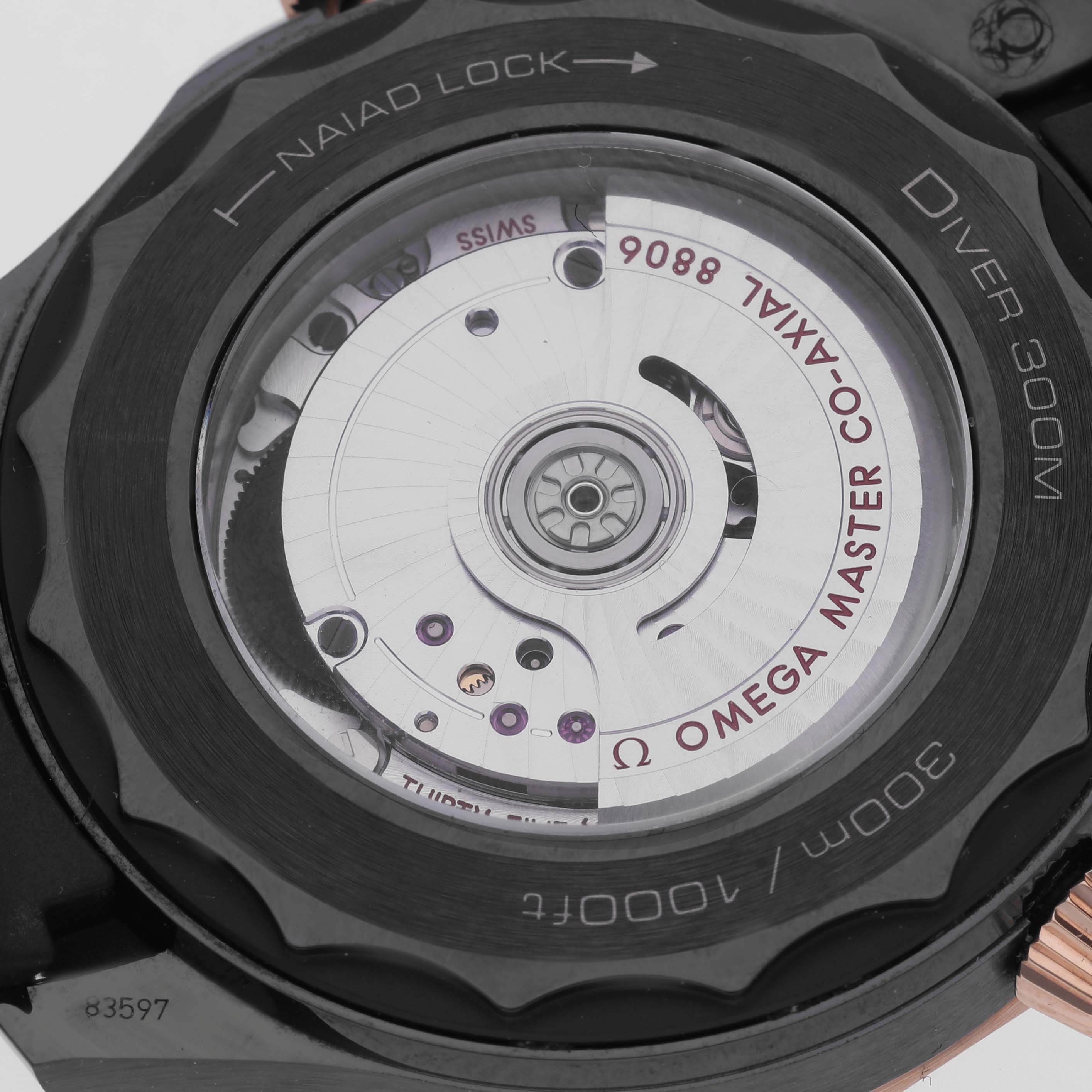 The image shows the back of the Omega Seamaster 210.62.44.20.01.001 Men's Ceramic Black Dial 210.62.44.20.01.001 Men's Ceramic Black Dial, highlighting its movement and "NAIAD LOCK" mechanism.