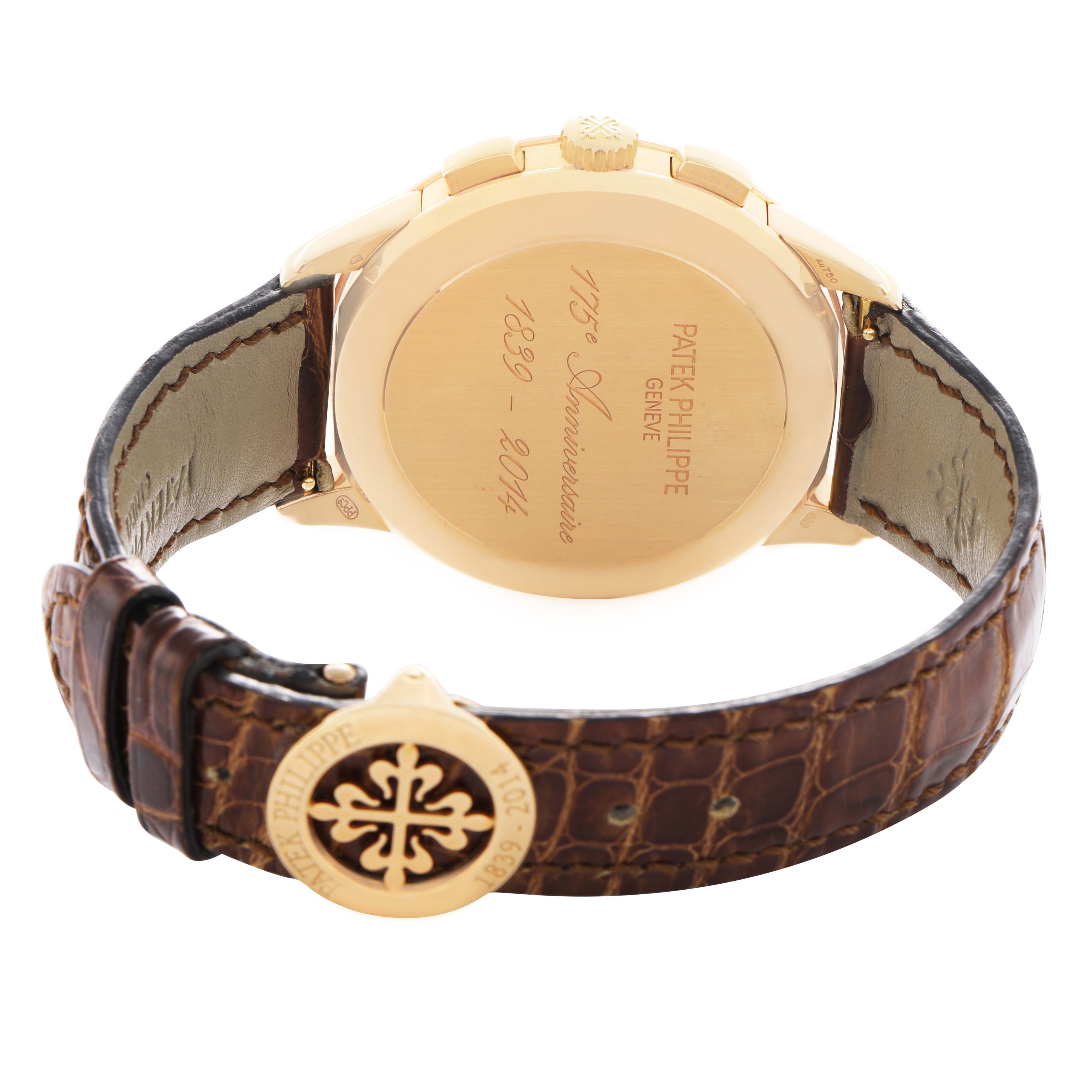 The image shows the Patek Philippe Complications 5975J-001 Men's Yellow Gold Silver Dial watch from the back, highlighting the engraved case back and brown leather strap with clasp.