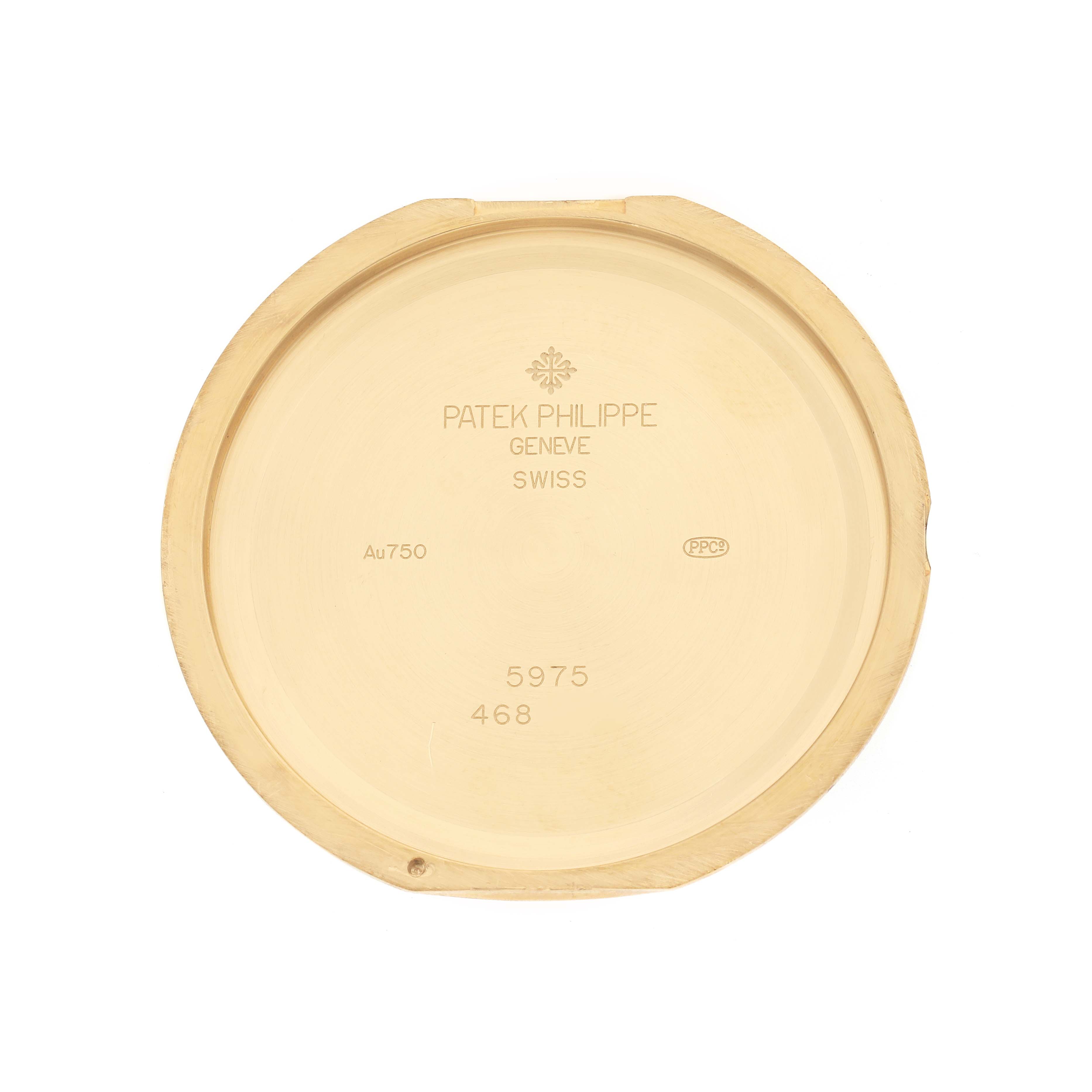 The image shows the back plate of a Patek Philippe Complications 5975J-001 Men's Yellow Gold Silver Dial watch, displaying engravings and markings.