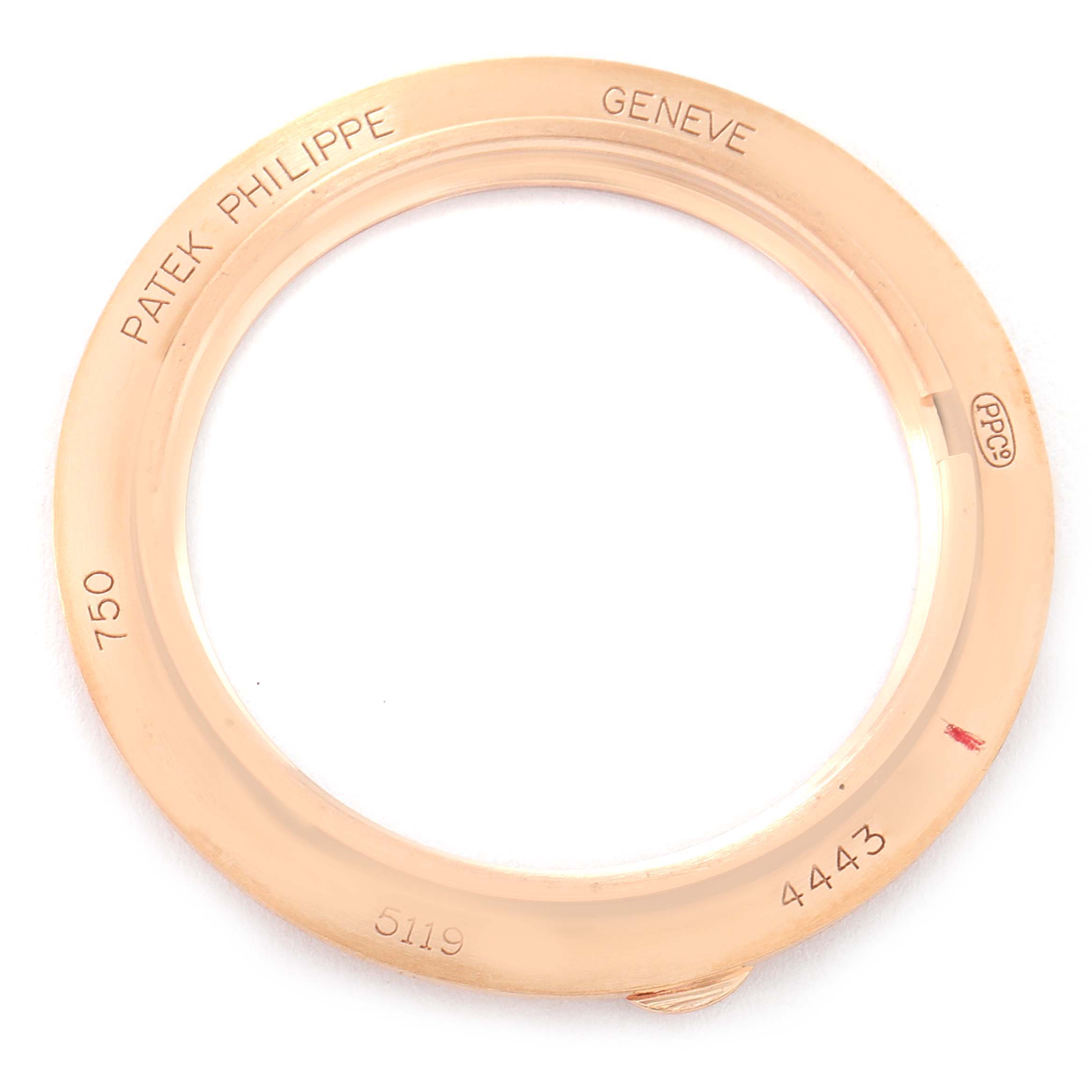 The image shows a gold bezel of a Patek Philippe Calatrava 5119R Men
s Rose Gold White Dial 5119R Men
s Rose Gold White Dial model watch, featuring engravings and hallmark stamps.