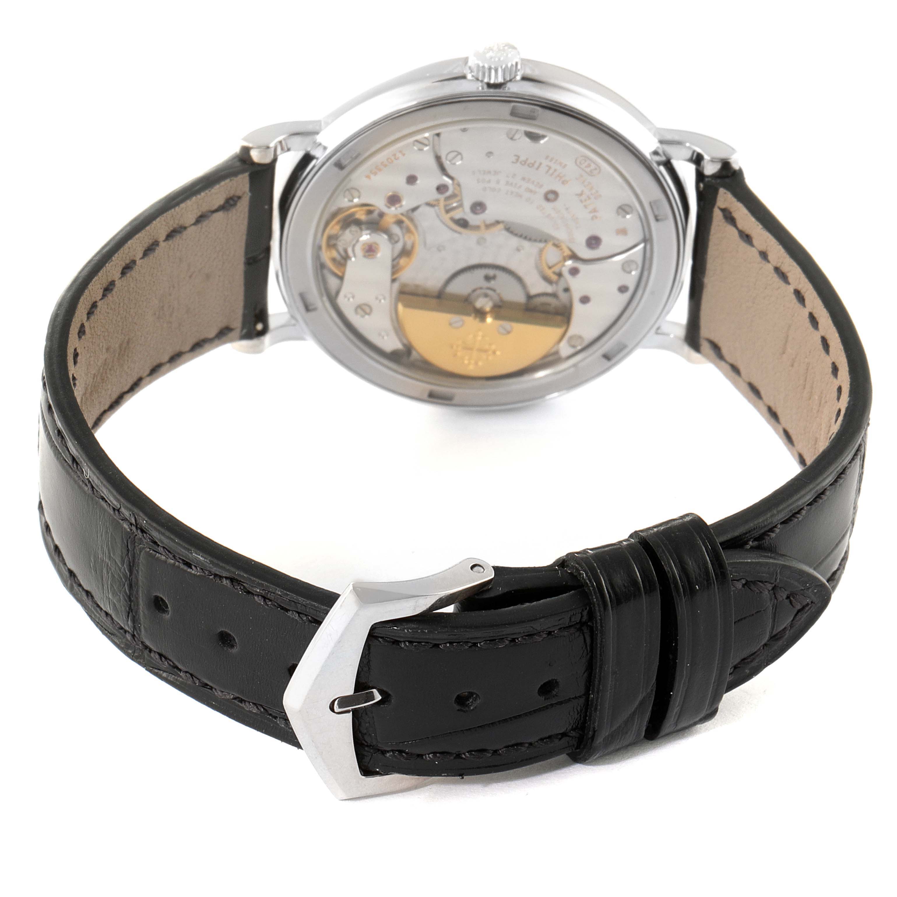The image shows the back view of a Patek Philippe Calatrava 5120G Men
s White Gold White Dial 5120G Men
s White Gold White Dial watch, highlighting the mechanical movement and a black leather strap.