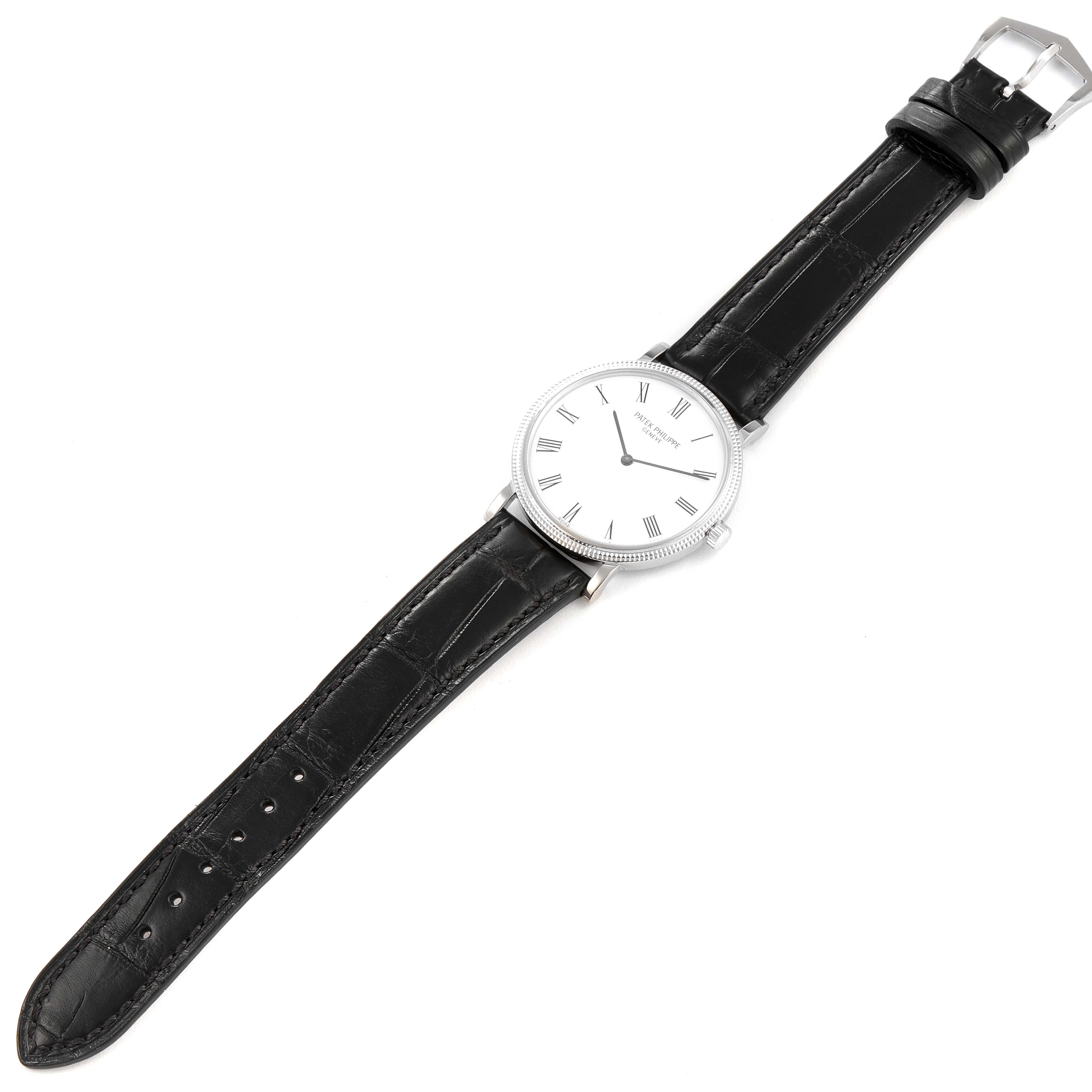 This image shows a Patek Philippe Calatrava 5120G Men
s White Gold White Dial 5120G Men
s White Gold White Dial watch laid flat, highlighting the watch face, black leather strap, and silver buckle.