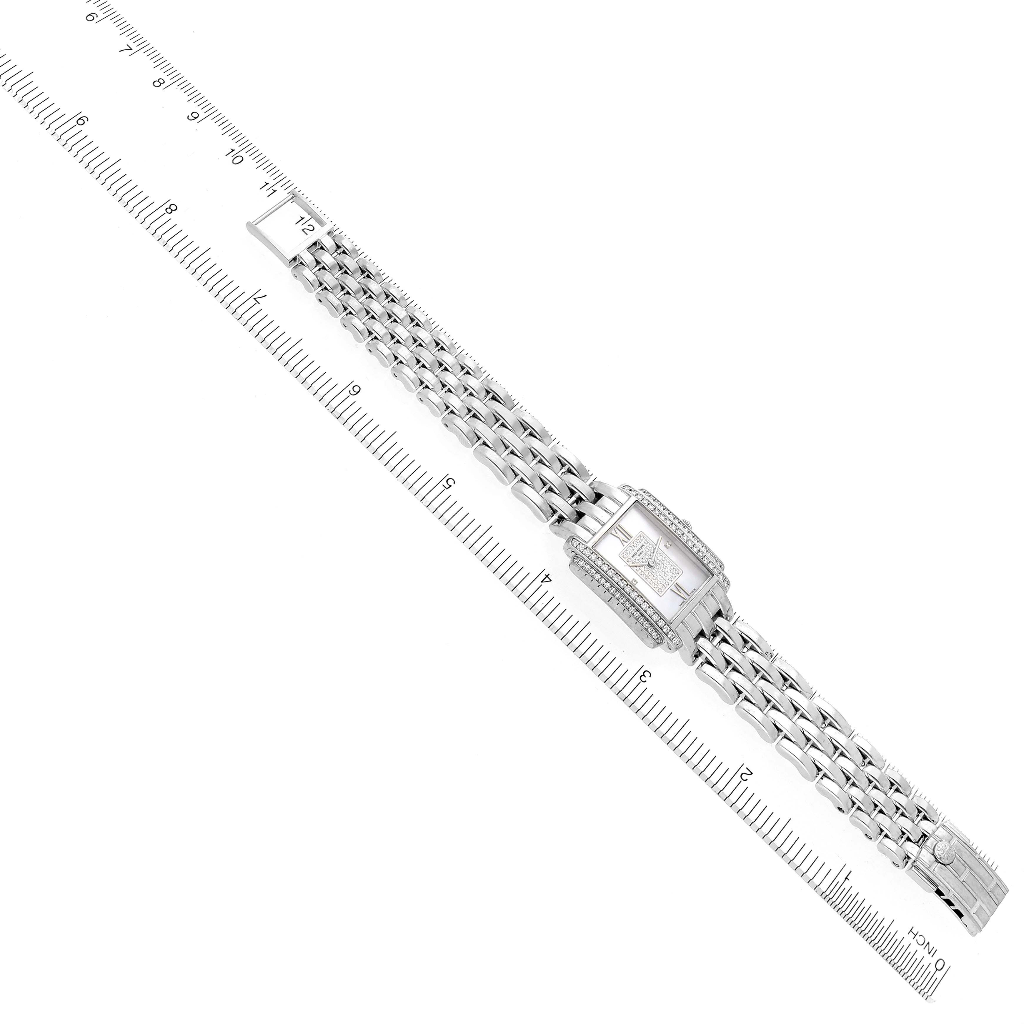 The Patek Philippe Gondolo 4825G Women
s White Gold Mother of Pearl Dial 4825G Women
s White Gold Mother of Pearl Dial watch is shown from a top-down angle, highlighting the dial, bracelet, and clasp alongside a ruler.