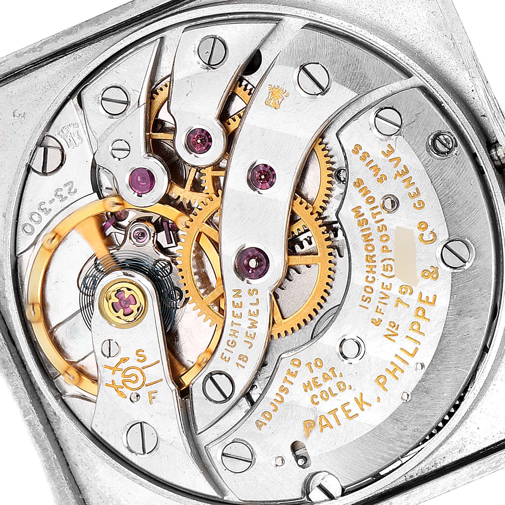This image shows the intricate internal mechanism of a Vintage Patek Philippe watch, featuring gears and jewels.