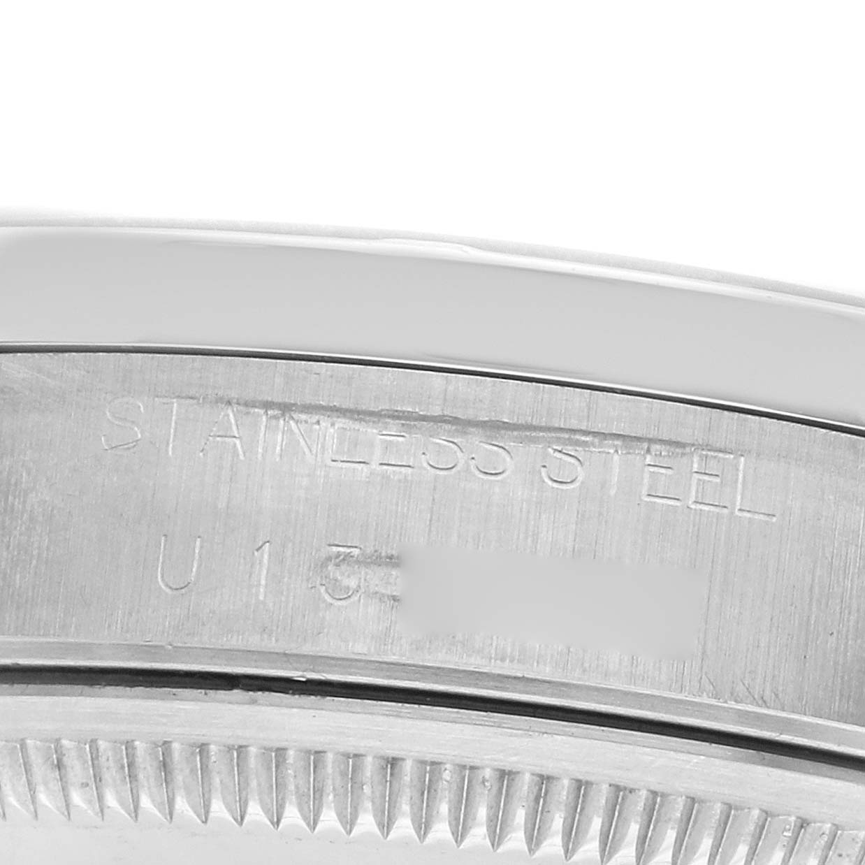 The image shows a close-up of the stainless steel case side with engravings on a Rolex Date 15210 Men's Stainless Steel Silver Dial model watch.