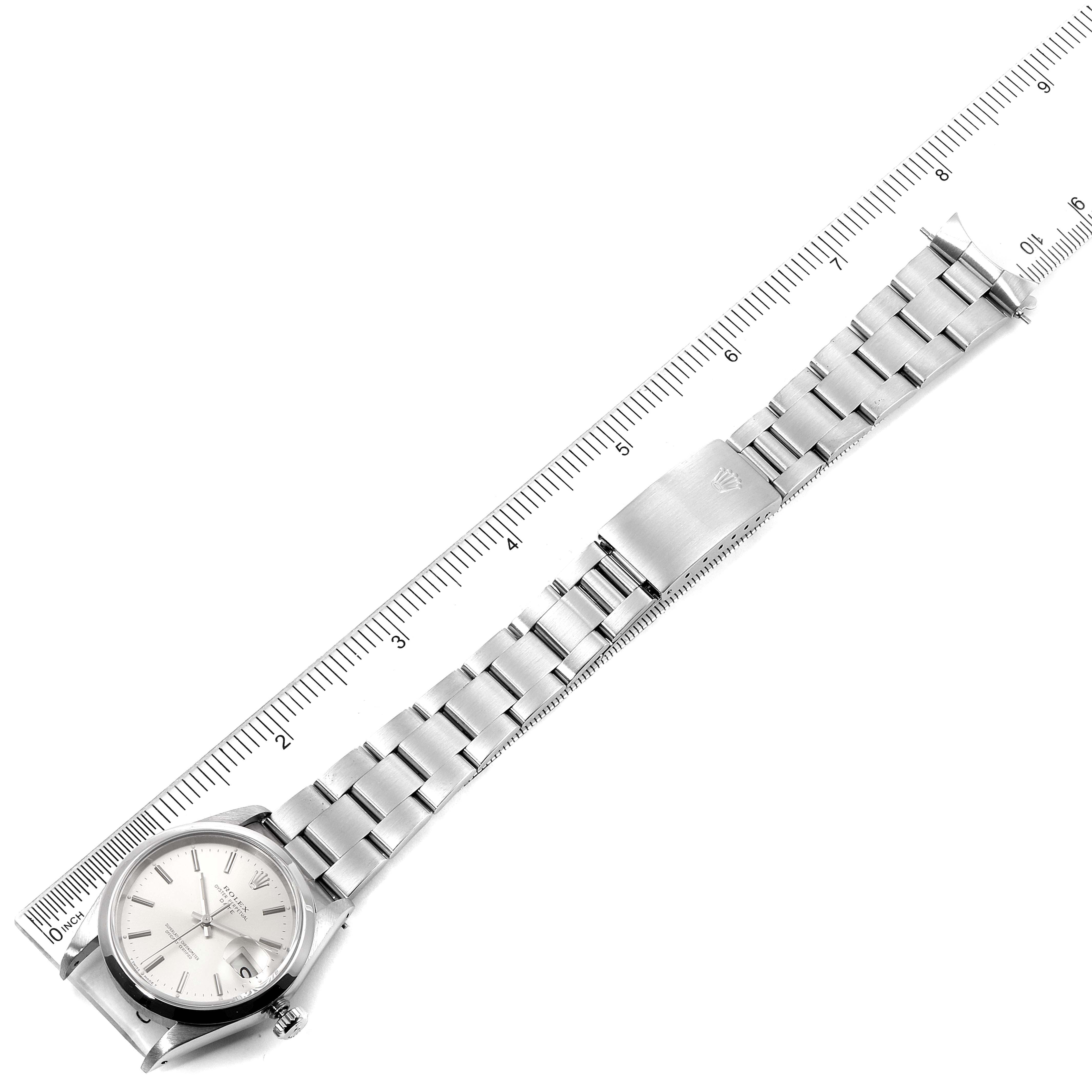 The image shows a top view of a Rolex Date 15200 Men's Stainless Steel Silver Dial 15200 Men's Stainless Steel Silver Dial model watch, including its face and metal bracelet laid against a ruler.