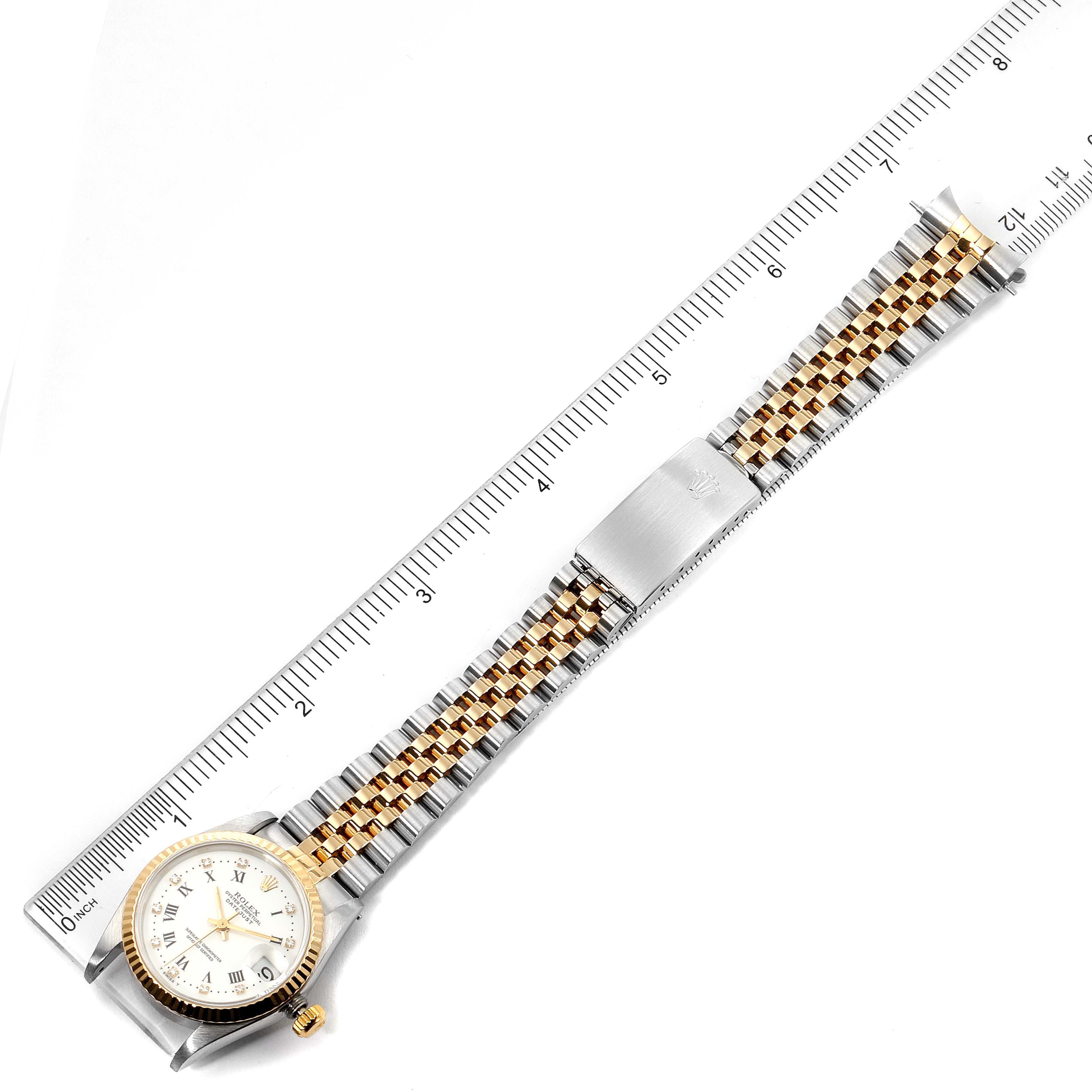 The image shows the front view of a Rolex Datejust 68273 Women
s Steel and Gold (two tone) White Dial 68273 Women
s Steel and Gold (two tone) White Dial watch, including the face and entire bracelet, which is aligned with a ruler for measurement.