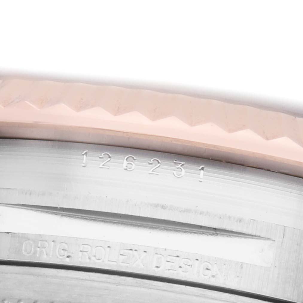 The image shows a close-up of the engraved edge of a Rolex Datejust 126231 Men's Stainless Steel Grey Dial model, focusing on the watch's serial and design numbers.