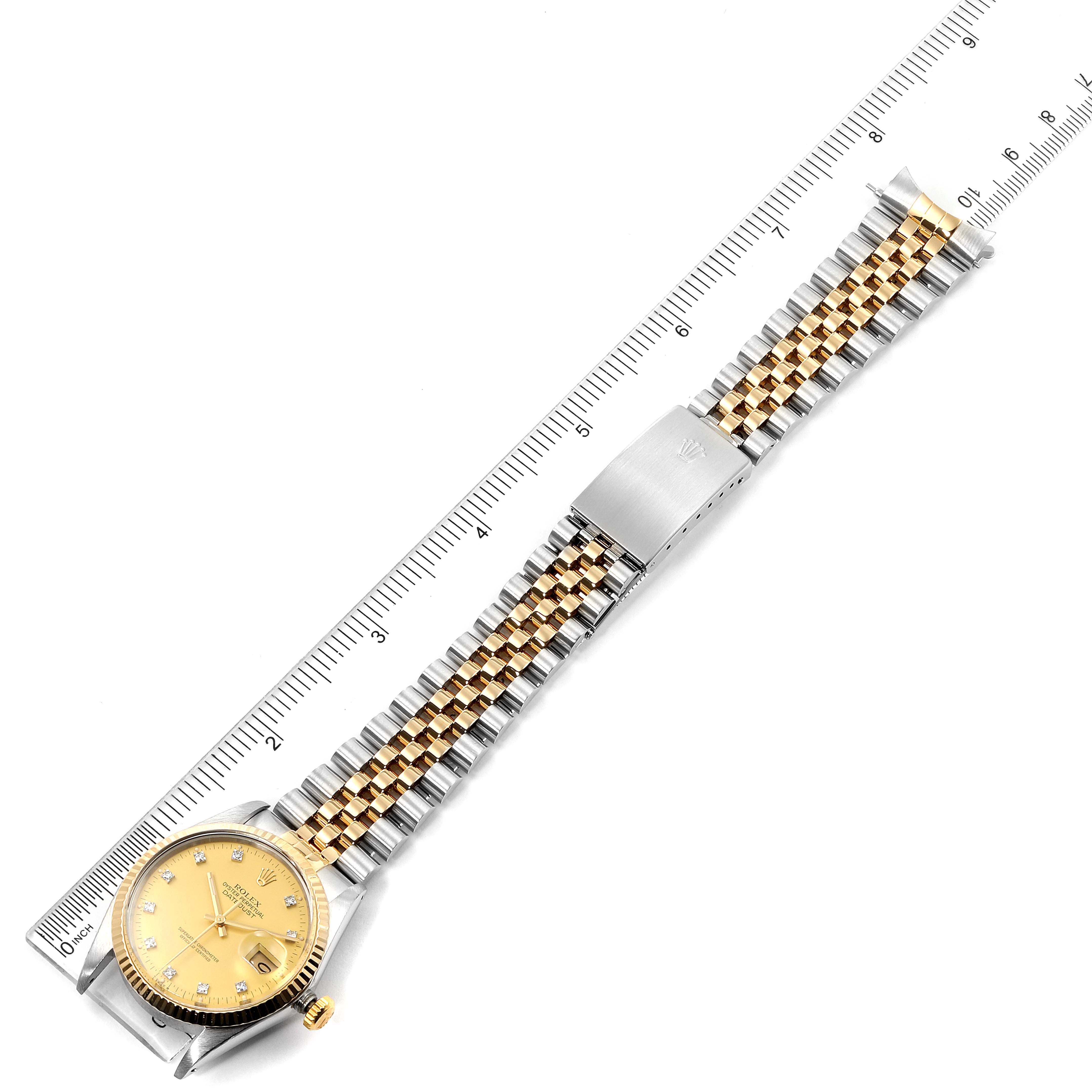 The image shows a top-down view of a Rolex Datejust 16013 Men
s Steel and Gold (two tone) Champagne Dial 16013 Men
s Steel and Gold (two tone) Champagne Dial watch, highlighting its gold dial, two-tone jubilee bracelet, and clasp against a ruler.