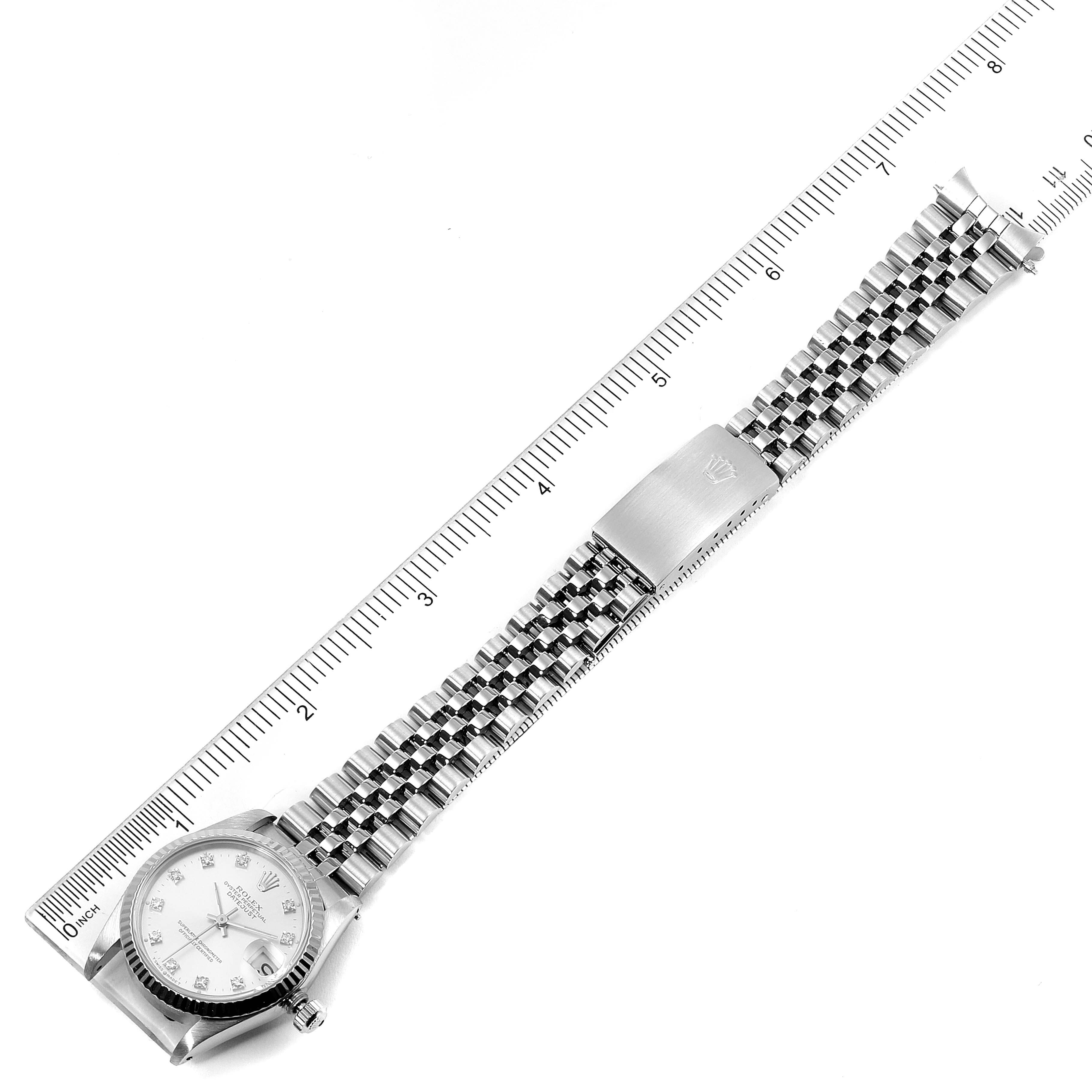 This image shows a Rolex Mid-Size 68274 Women
s Stainless Steel Silver Dial 68274 Women
s Stainless Steel Silver Dial watch laying flat with its dial, bezel, and full bracelet visible next to a measuring ruler.