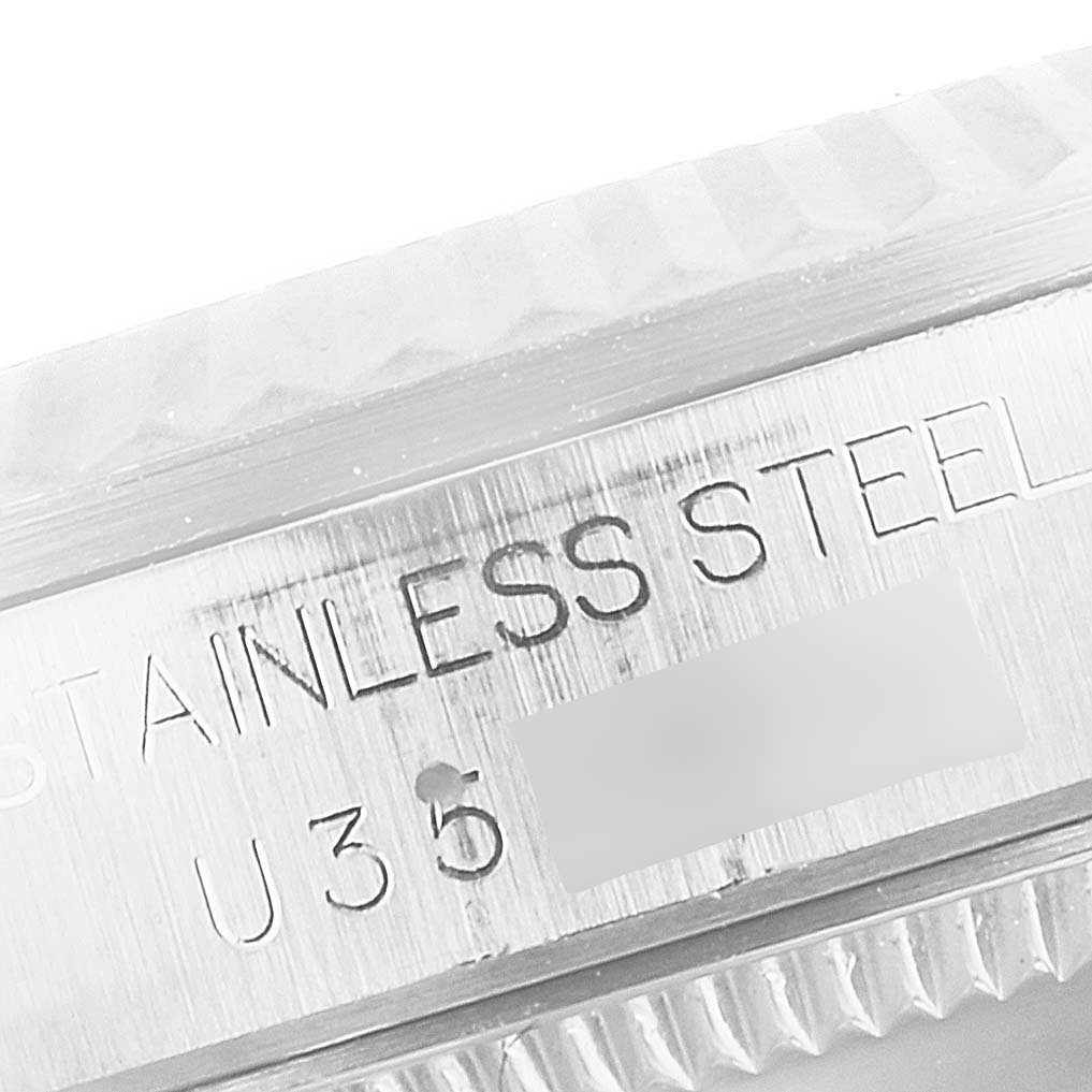 This image shows a close-up of the case side of a Rolex Mid-Size 68274 Women
s Stainless Steel Black Dial 68274 Women
s Stainless Steel Black Dial watch, highlighting the "STAINLESS STEEL" engraving.