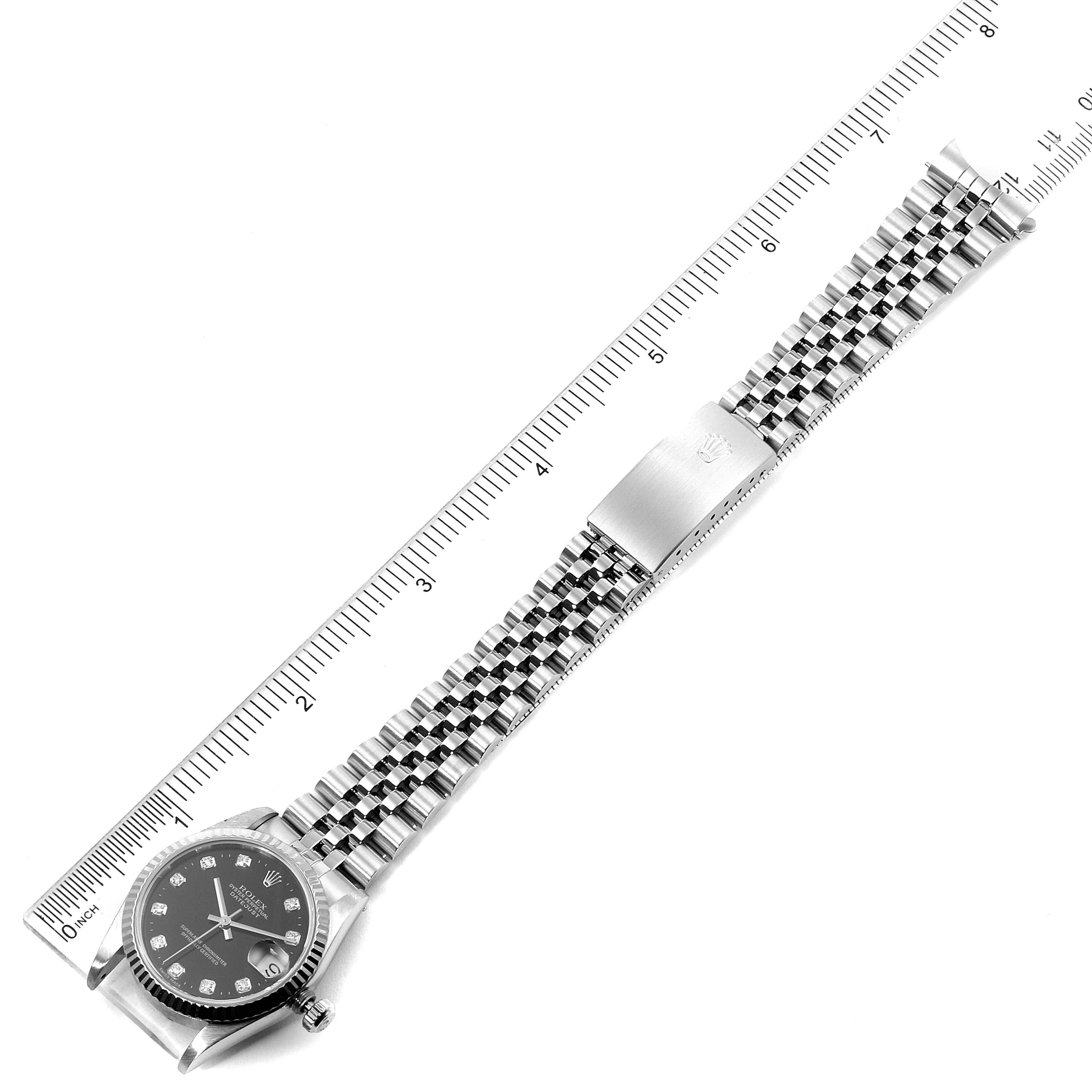 This is a top-down view of a Mid-Size Rolex watch showing the face, bracelet, and part of the clasp with a ruler for scale.