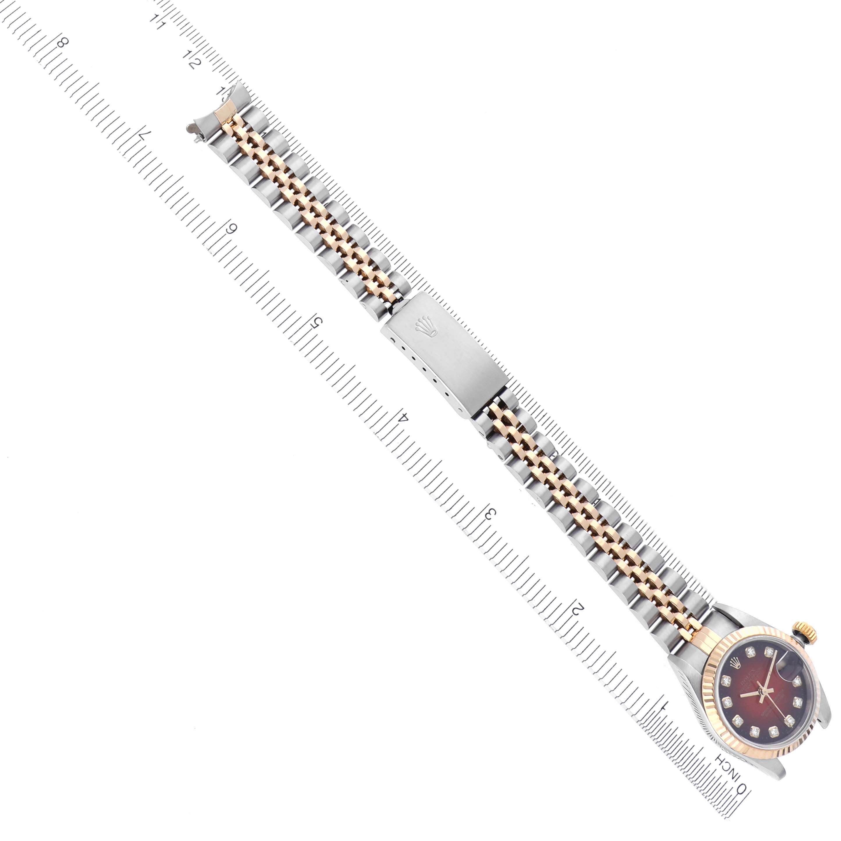 The image shows a Rolex Datejust 69173 Women's Steel and Gold (two tone) Red Dial 69173 Women's Steel and Gold (two tone) Red Dial watch at a top-down angle, highlighting the bracelet, clasp, and face alongside a ruler.