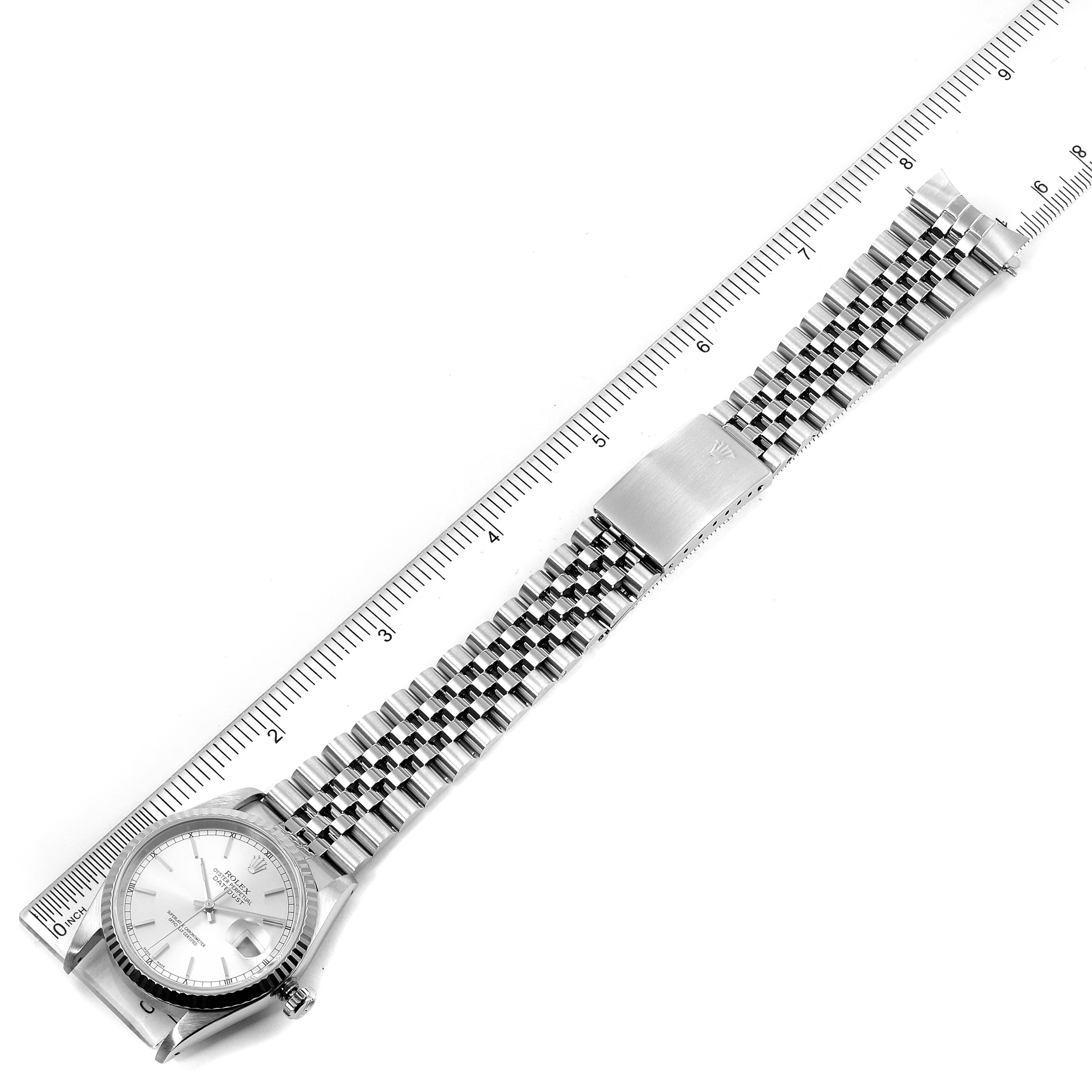 This image shows the entire watch strap and face of a Rolex Datejust 16234 Men's Stainless Steel Silver Dial 16234 Men's Stainless Steel Silver Dial model placed against a ruler for measurement.
