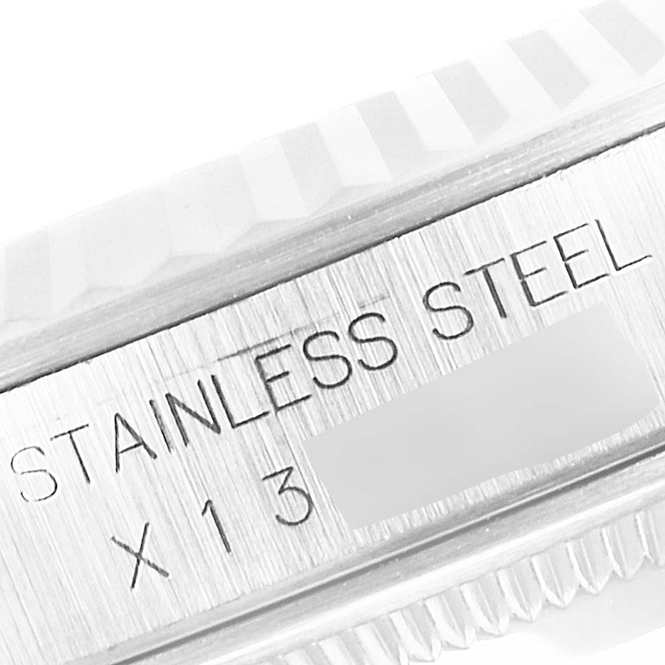 The image shows a close-up of the side of the Rolex Datejust 16234 Men
s Stainless Steel Silver Dial 16234 Men
s Stainless Steel Silver Dial watch, focusing on its stainless steel marking and part of the bezel.