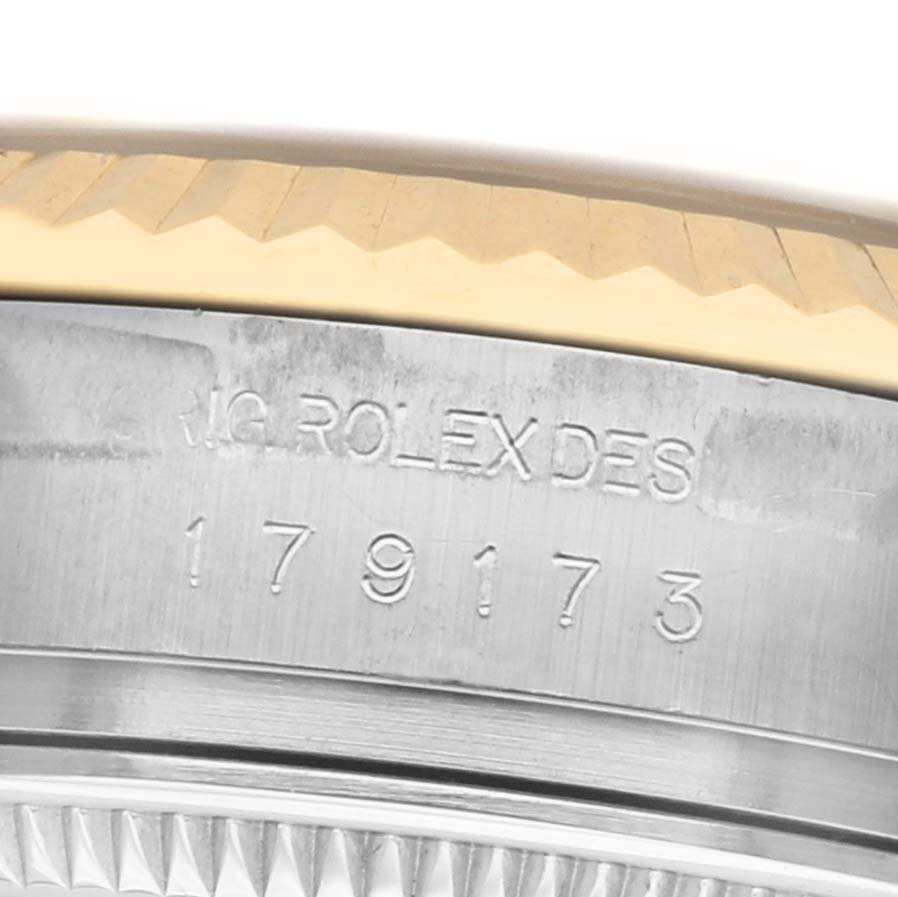 The image shows a close-up of the engraved side of a Rolex Datejust 179173 Women's Steel and Gold (two tone) Champagne Dial watch, focusing on the model number and serial details.