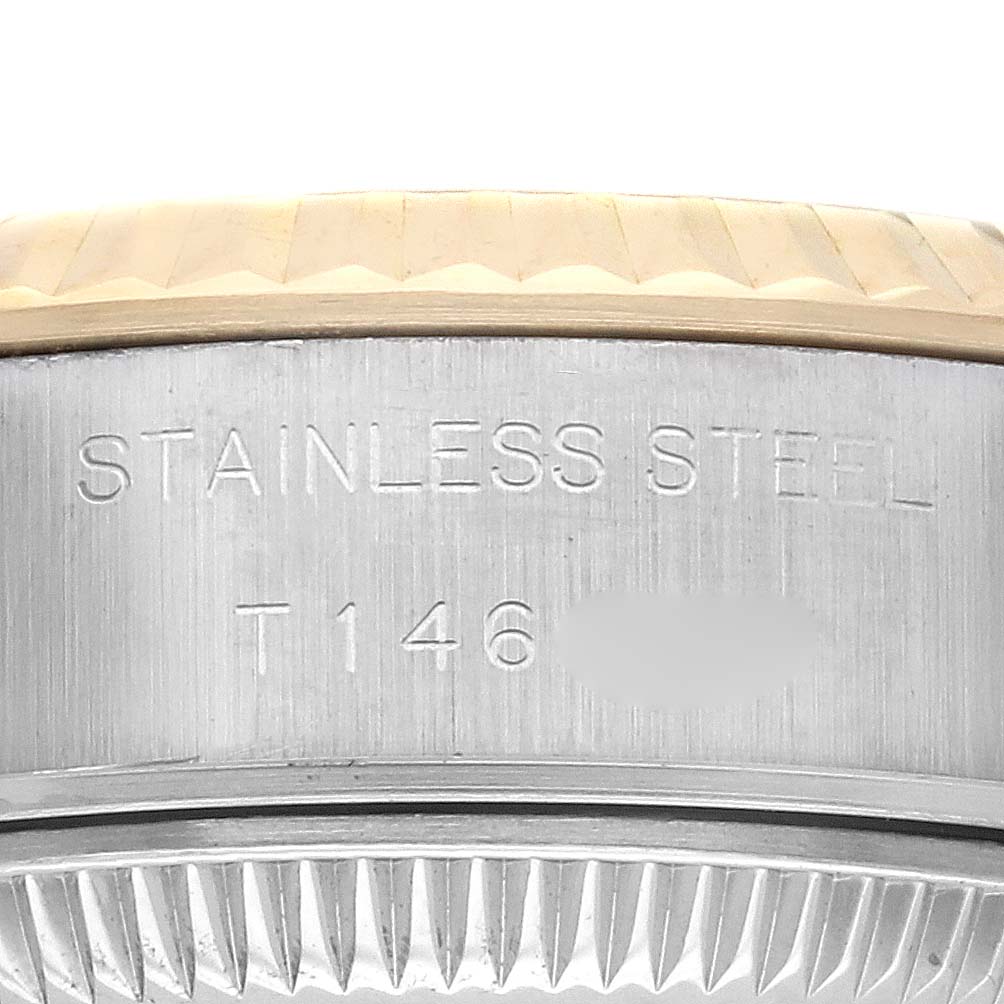 The image shows the side view of a Rolex Datejust 69173 Women
s Steel and Gold (two tone) Champagne Dial 69173 Women
s Steel and Gold (two tone) Champagne Dial watch with "Stainless Steel" engraved on the case.