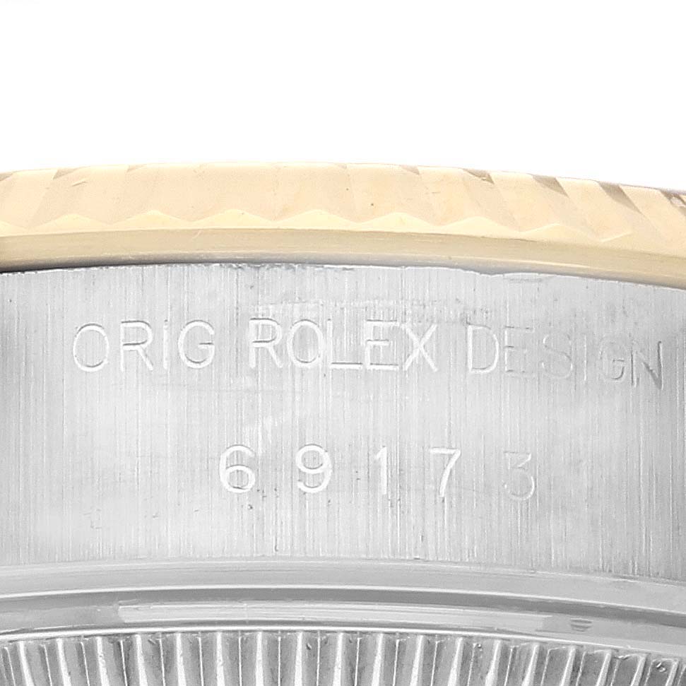 This image shows the side view of the Rolex Datejust 69173 Women
s Steel and Gold (two tone) Champagne Dial 69173 Women
s Steel and Gold (two tone) Champagne Dial case, featuring the engraving "ORIG ROLEX DESIGN 69173" and the bezel.