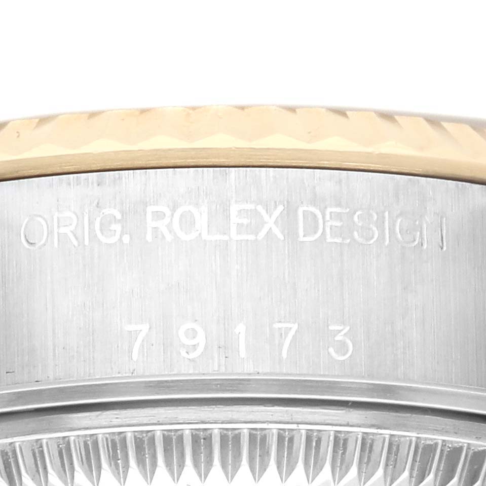 The image shows a close-up of the side of a Rolex Datejust 79173 Men's Steel and Gold (two tone) Champagne Dial 79173 Men's Steel and Gold (two tone) Champagne Dial, highlighting the serial number and fluted bezel.